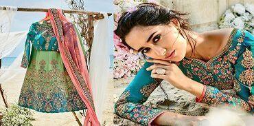 Woman in turquoise and pink embroidered lehenga choli posing outdoors with floral decor