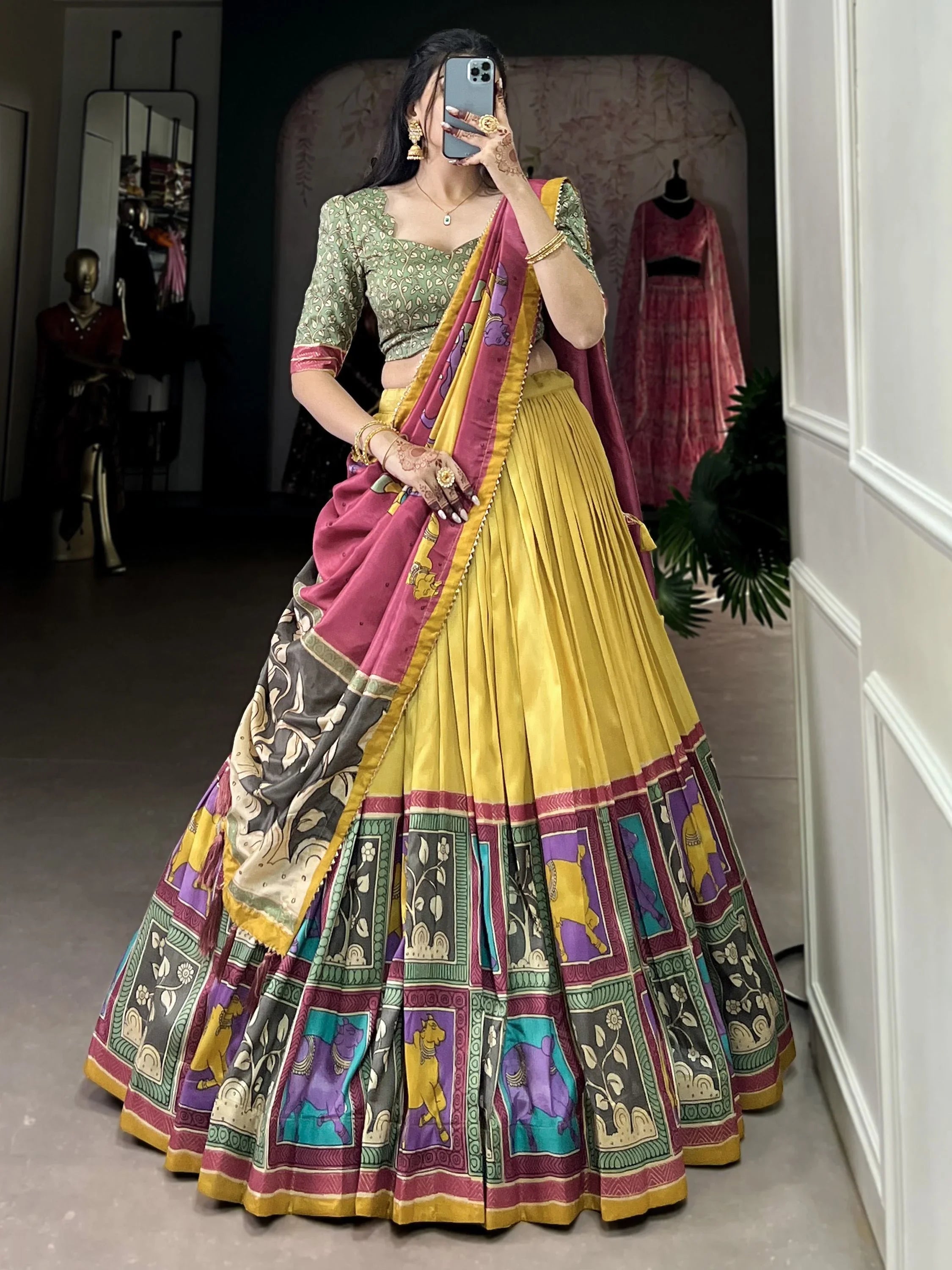 Woman wearing a colorful Navratri lehenga choli with yellow skirt, green blouse, and printed dupatta.