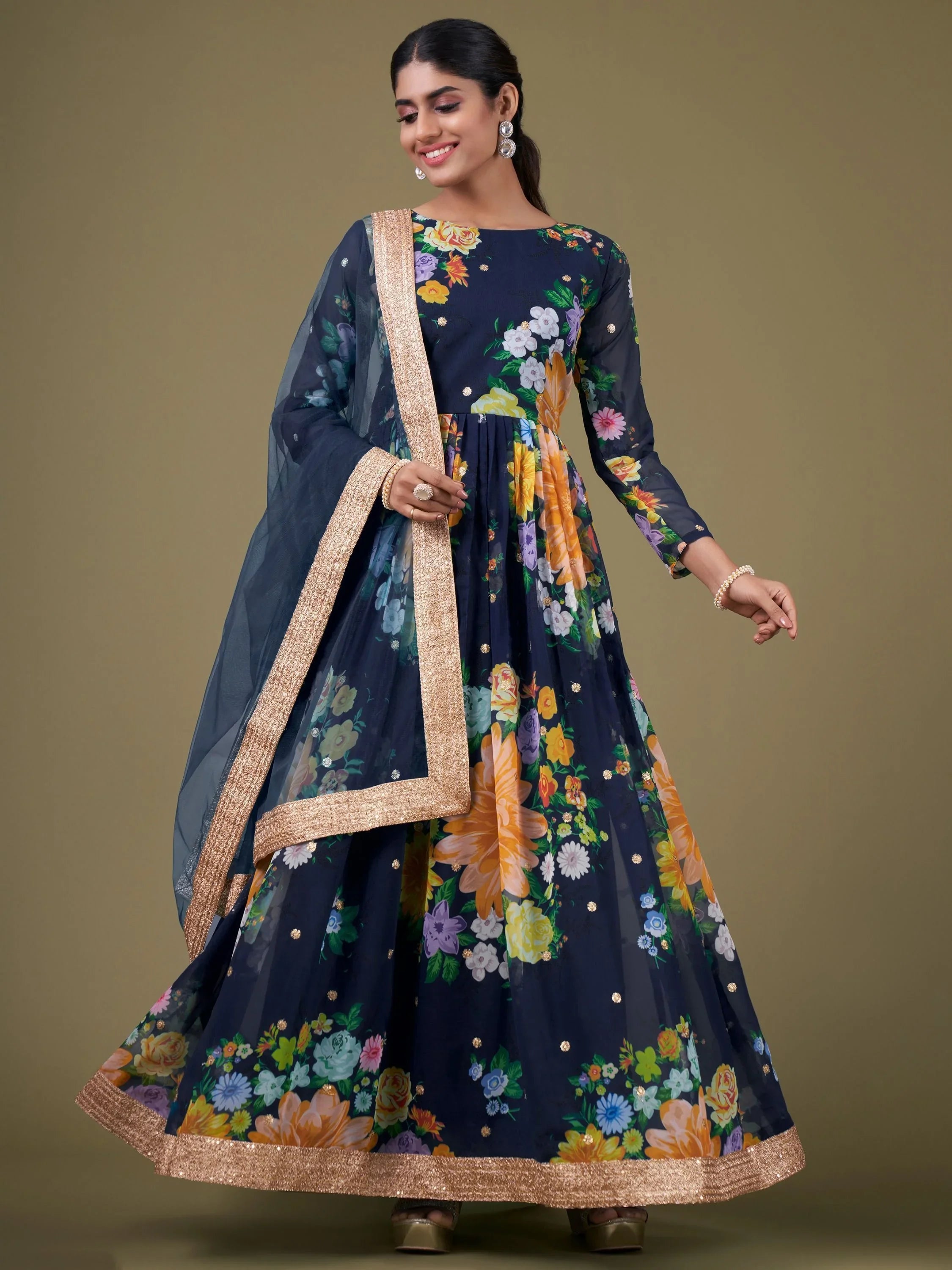 Woman wearing navy blue floral ethnic gown with gold border and matching dupatta