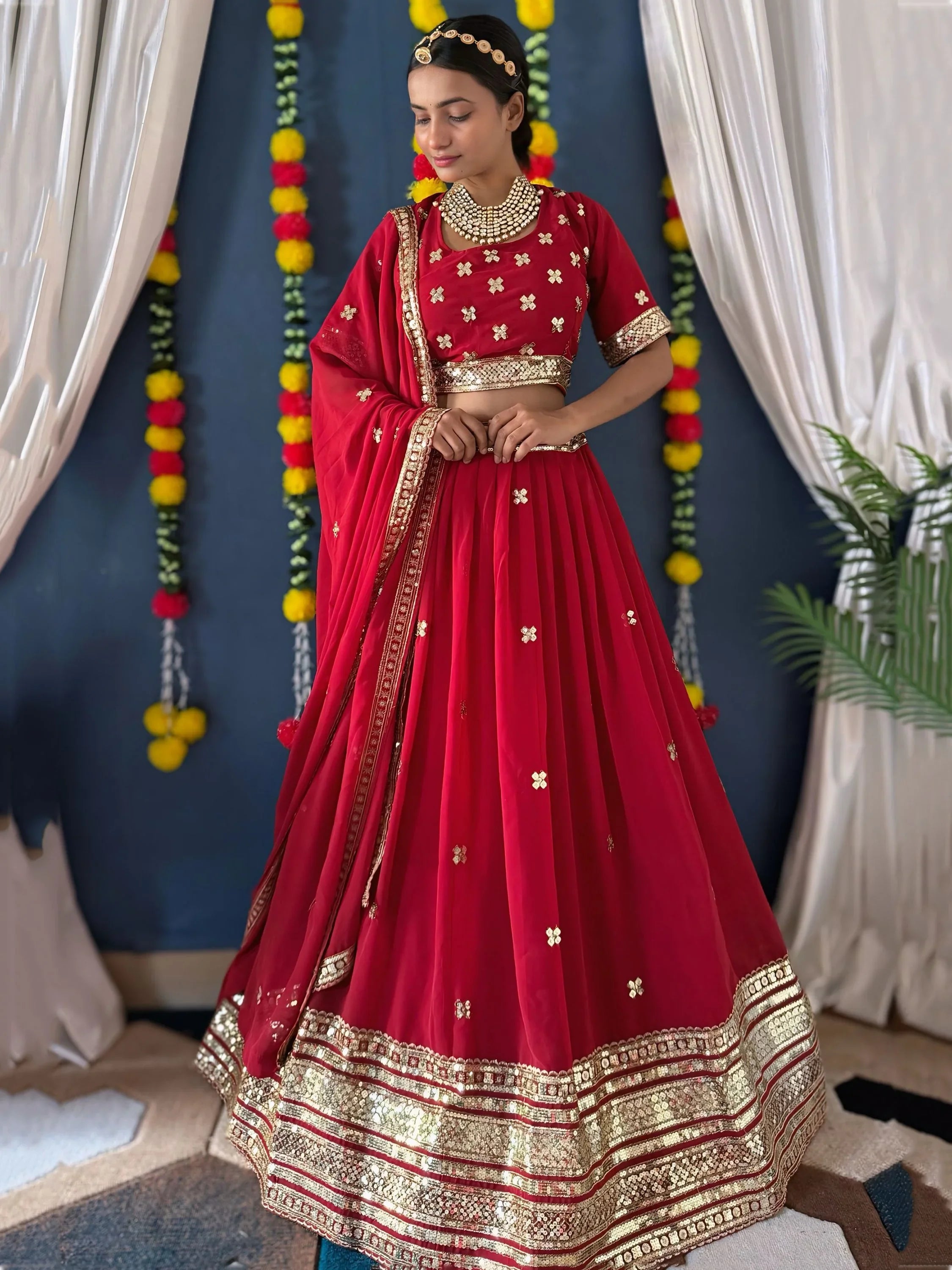 Woman in red shantoon bridal lehenga choli with gold embroidery, traditional Indian attire