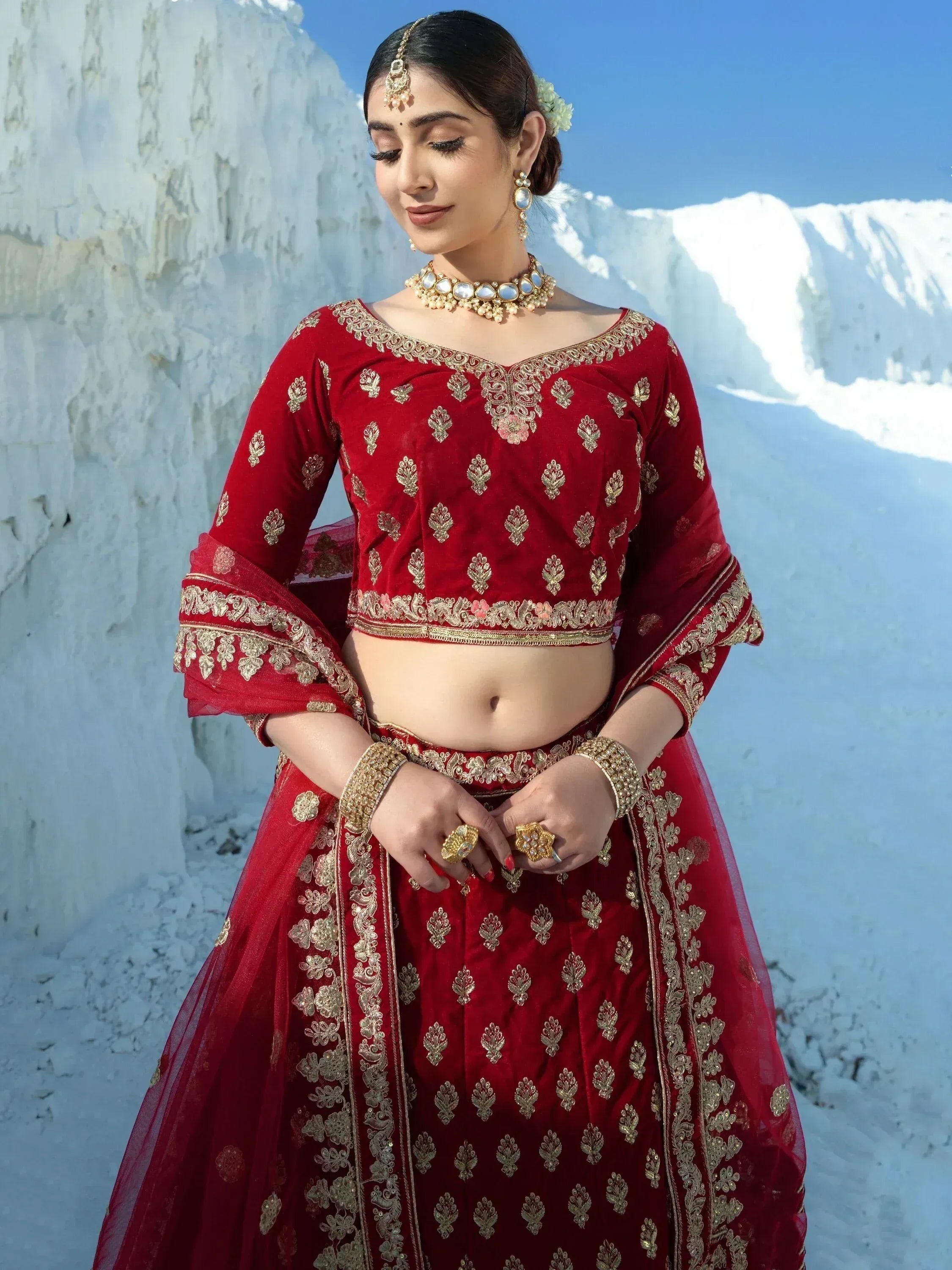 Red velvet lehenga choli with gold embroidery, perfect for Indian weddings and festive occasions