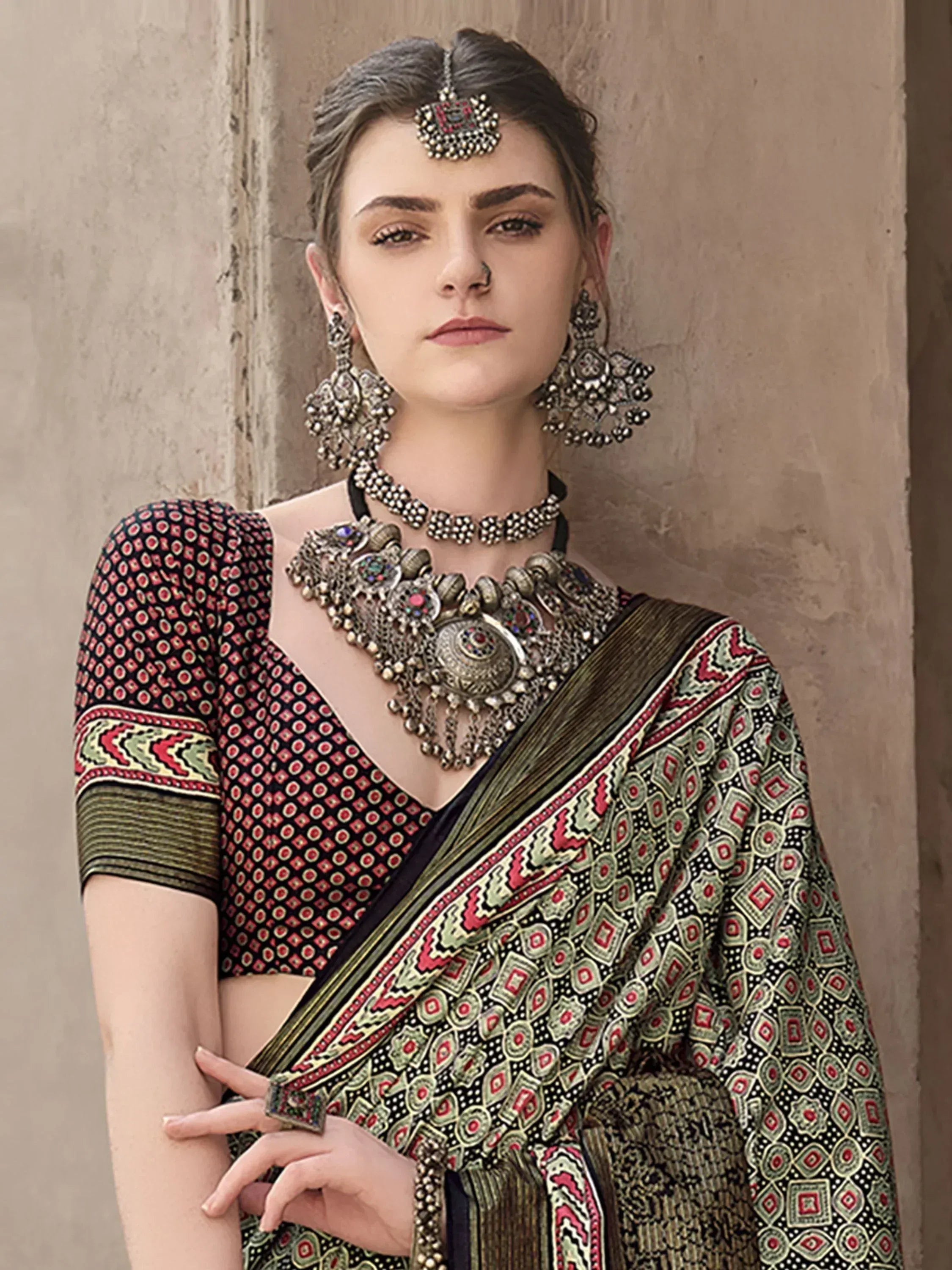 Woman in traditional Indian saree with intricate patterns and ethnic jewelry, perfect for festive occasions.