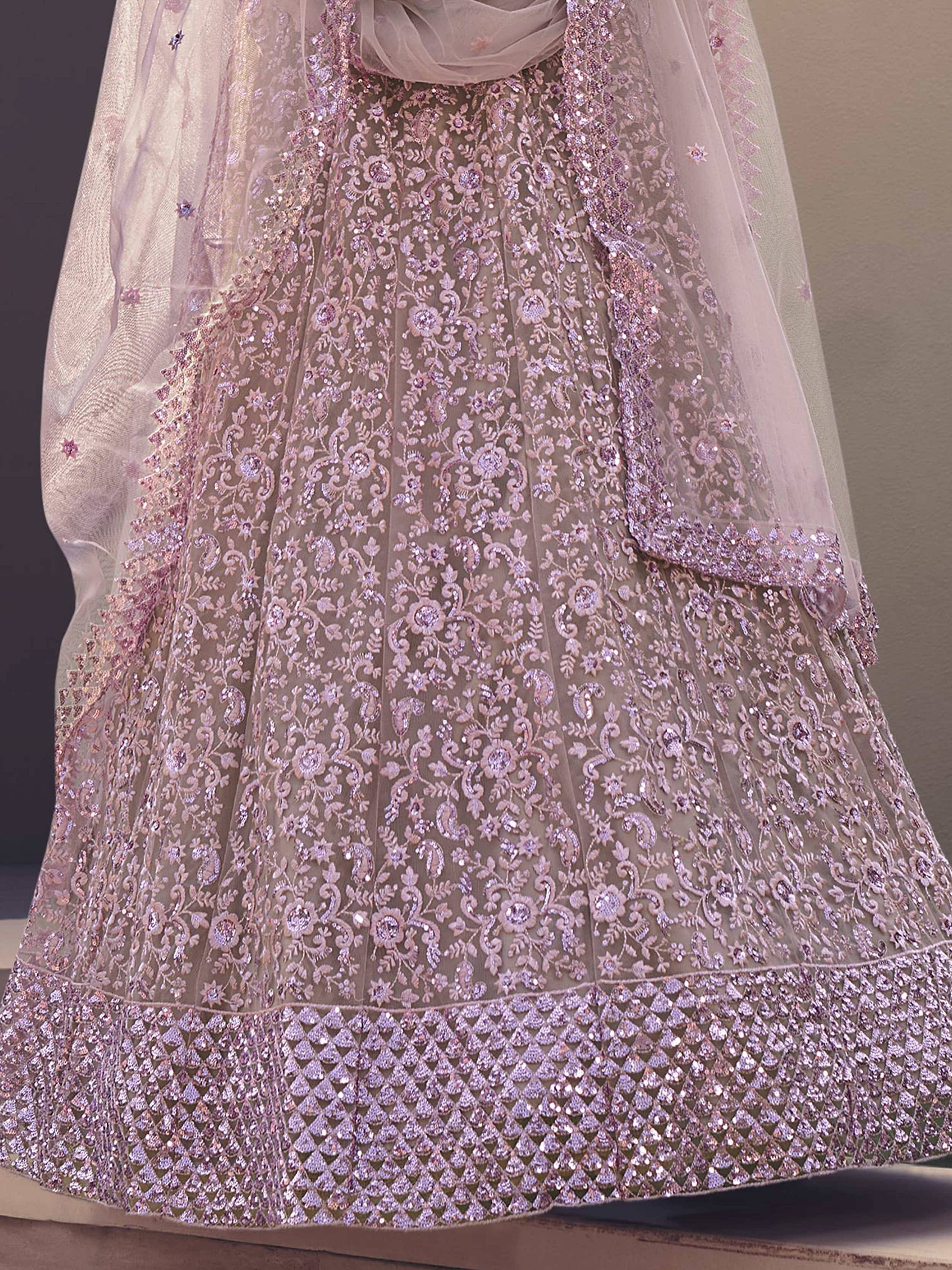 Elegant blush pink lehenga choli with intricate floral embroidery and sequin detailing, perfect for Indian weddings.