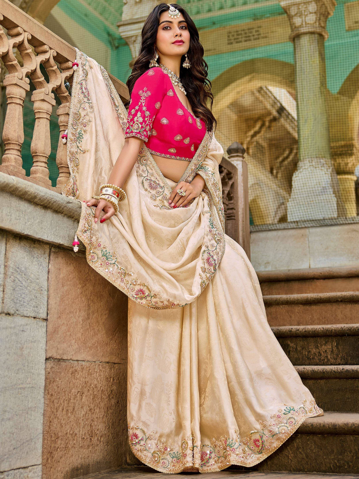 Elegant beige lehenga choli with pink blouse, floral embroidery, and gold detailing, perfect for Indian weddings and festive occasions.