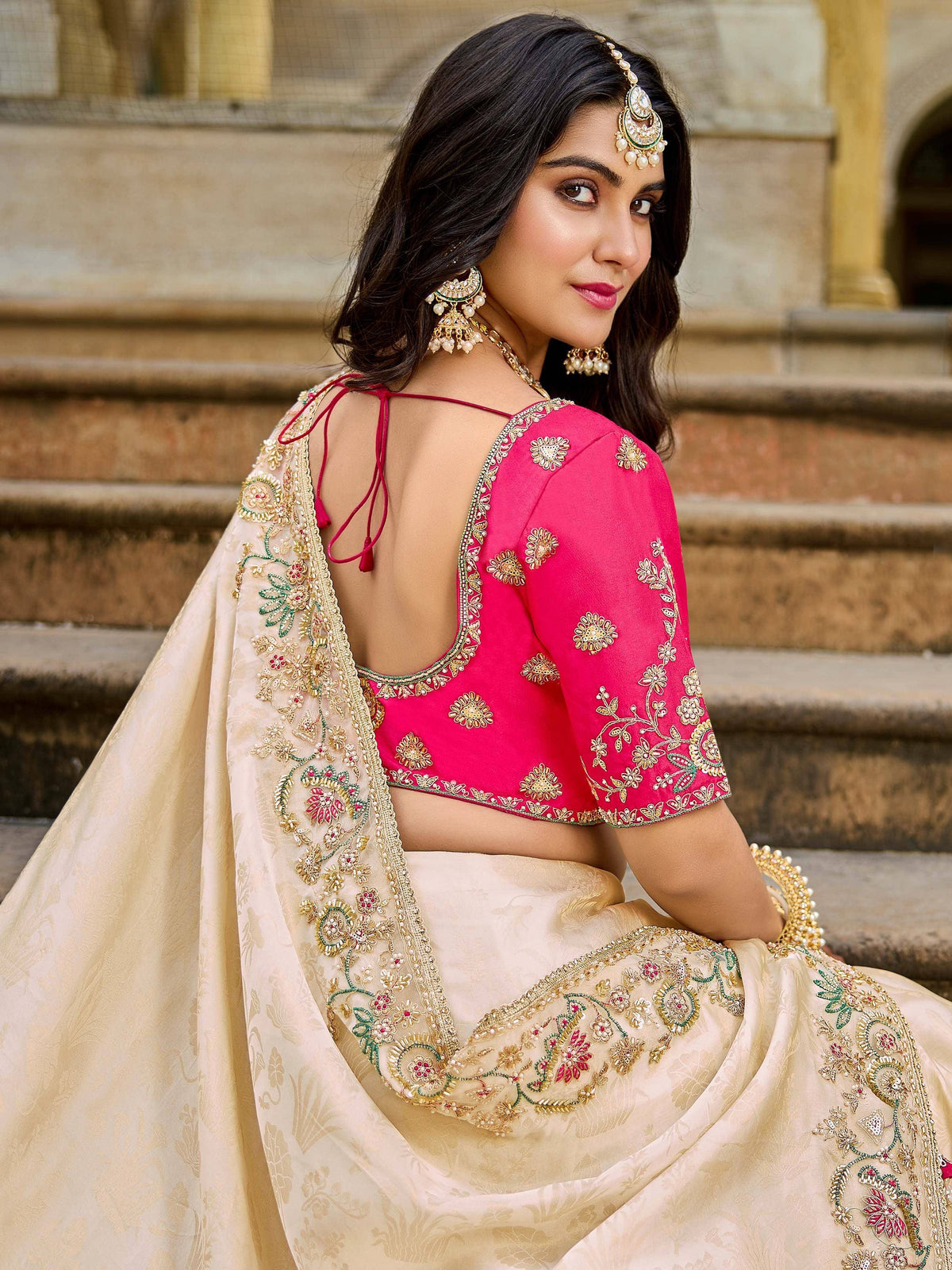 Pink embroidered blouse with back tie detail, paired with cream lehenga and dupatta, perfect for Indian ethnic wear.