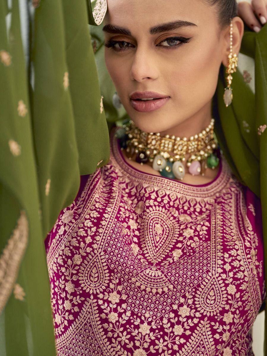 Woman in embroidered magenta ethnic saree blouse with heavy jewelry and green dupatta