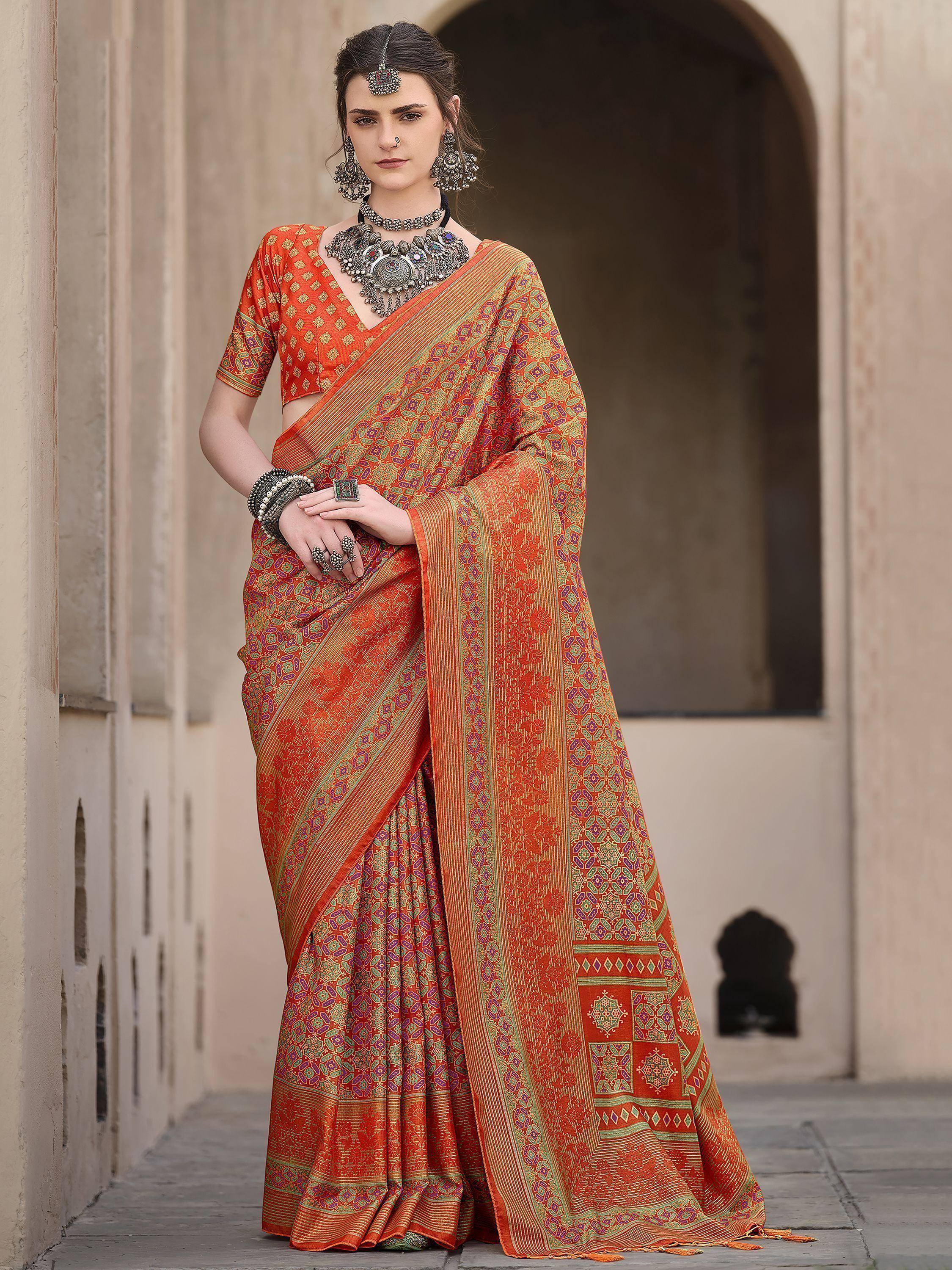Orange printed saree with ethnic jewelry, perfect for Indian occasions and festive wear