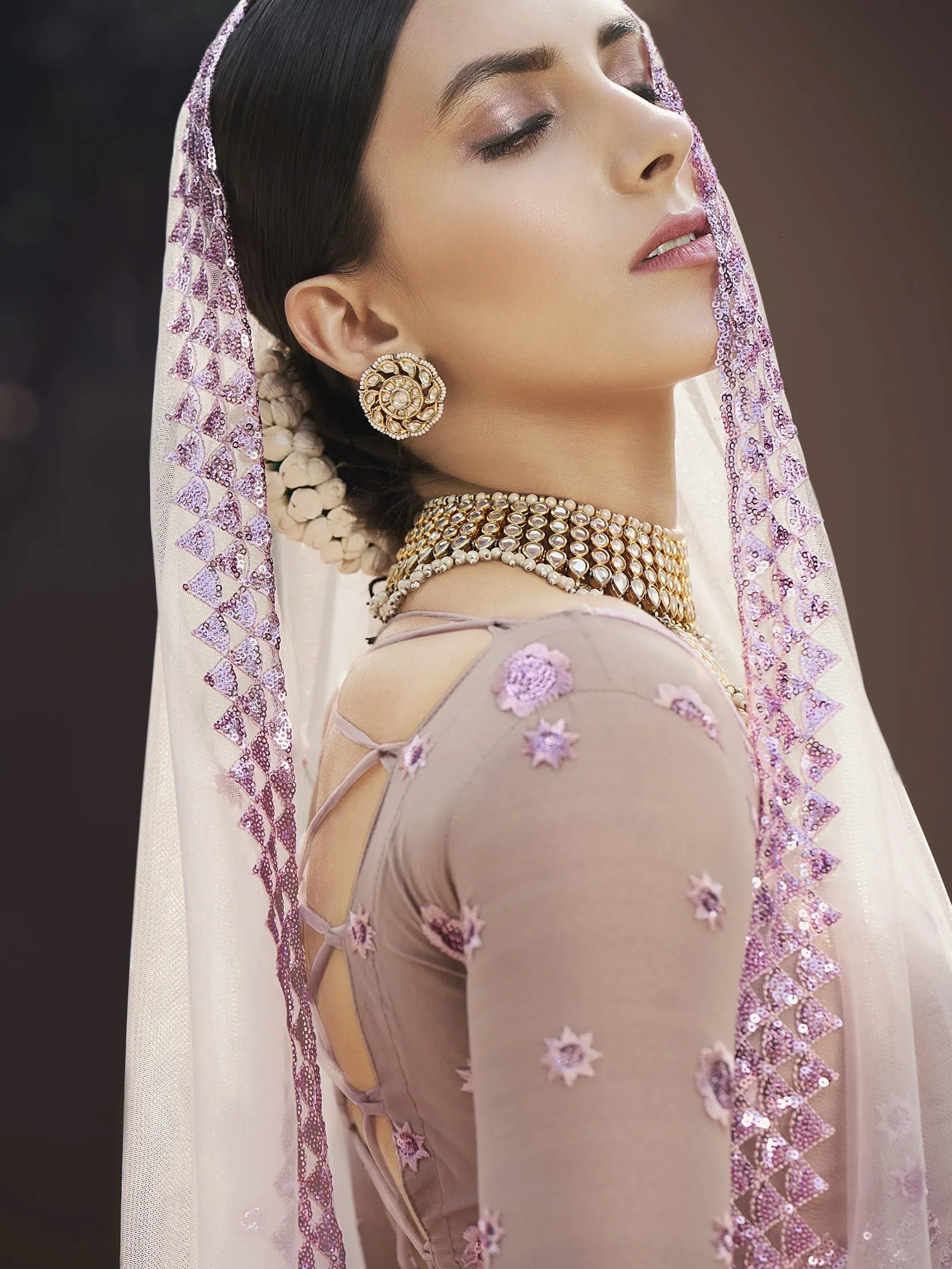 Elegant Indian ethnic wear with floral embroidery, sequin dupatta, and traditional jewelry for festive occasions.