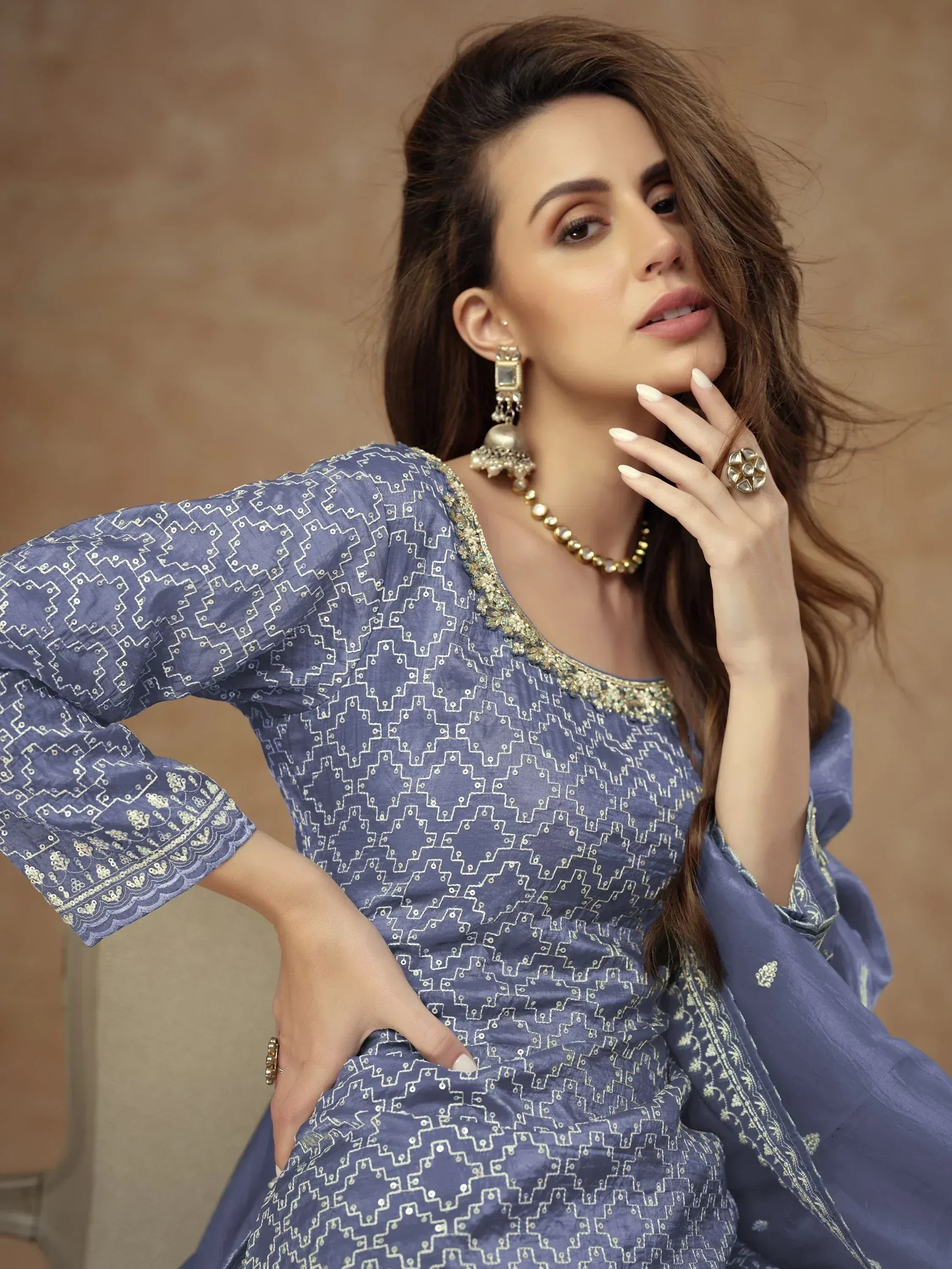 Blue embroidered ethnic gown with gold detailing, paired with traditional jewelry for festive occasions