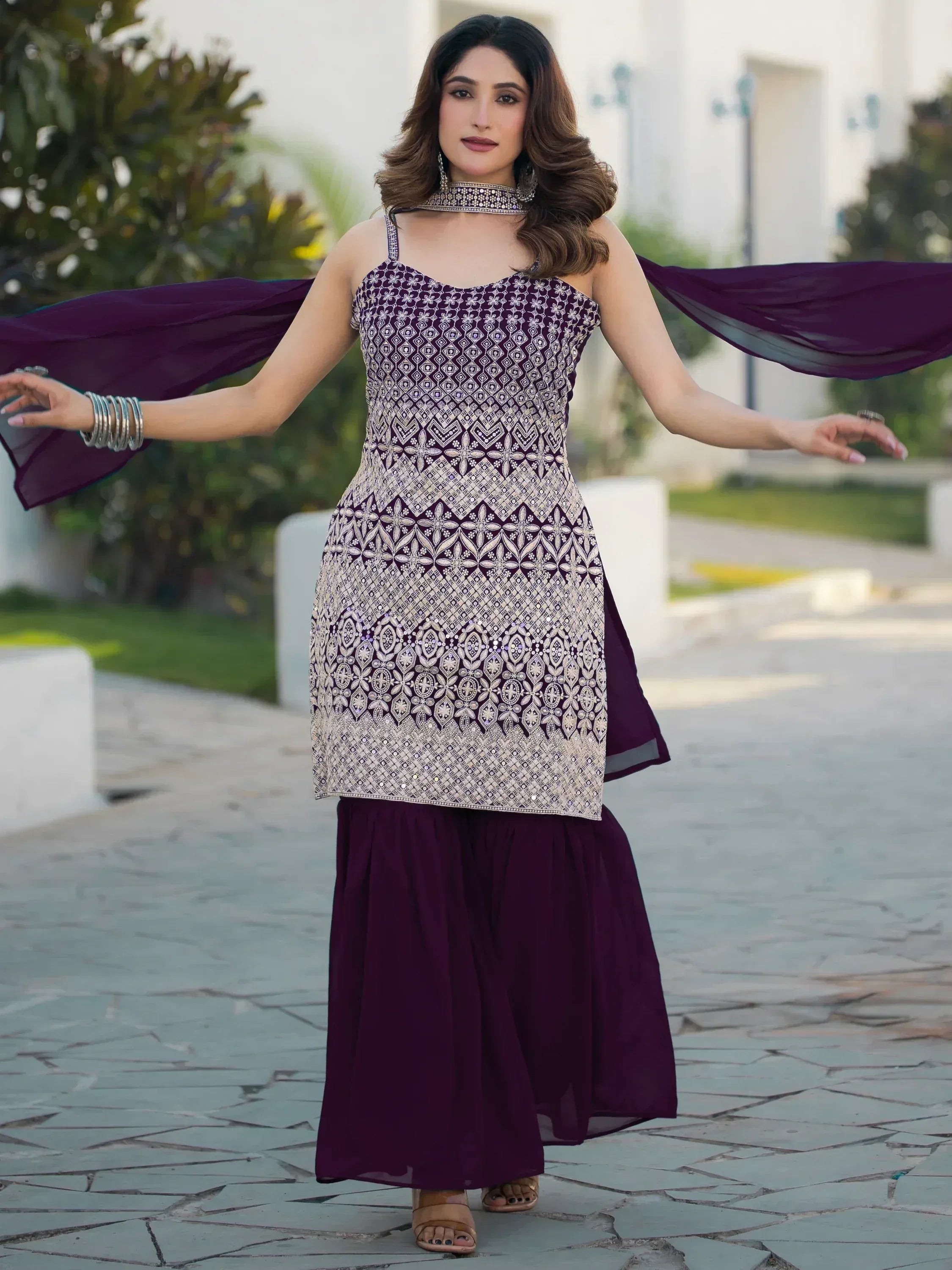 Purple ethnic gown with intricate silver embroidery, paired with matching dupatta and palazzo pants for festive occasions.
