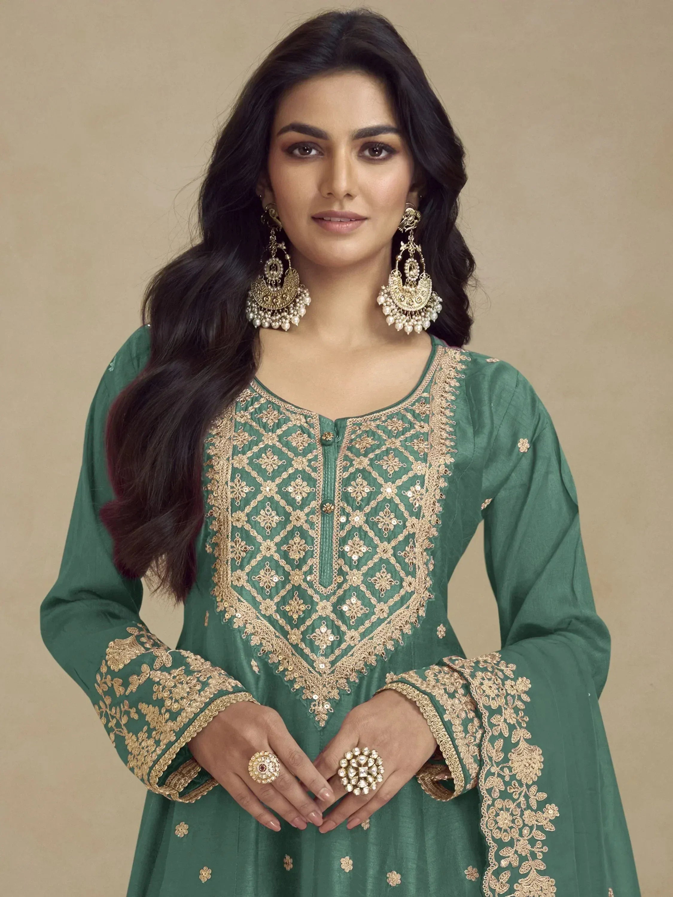Green embroidered ethnic kurti with gold detailing, paired with statement earrings for festive occasions.