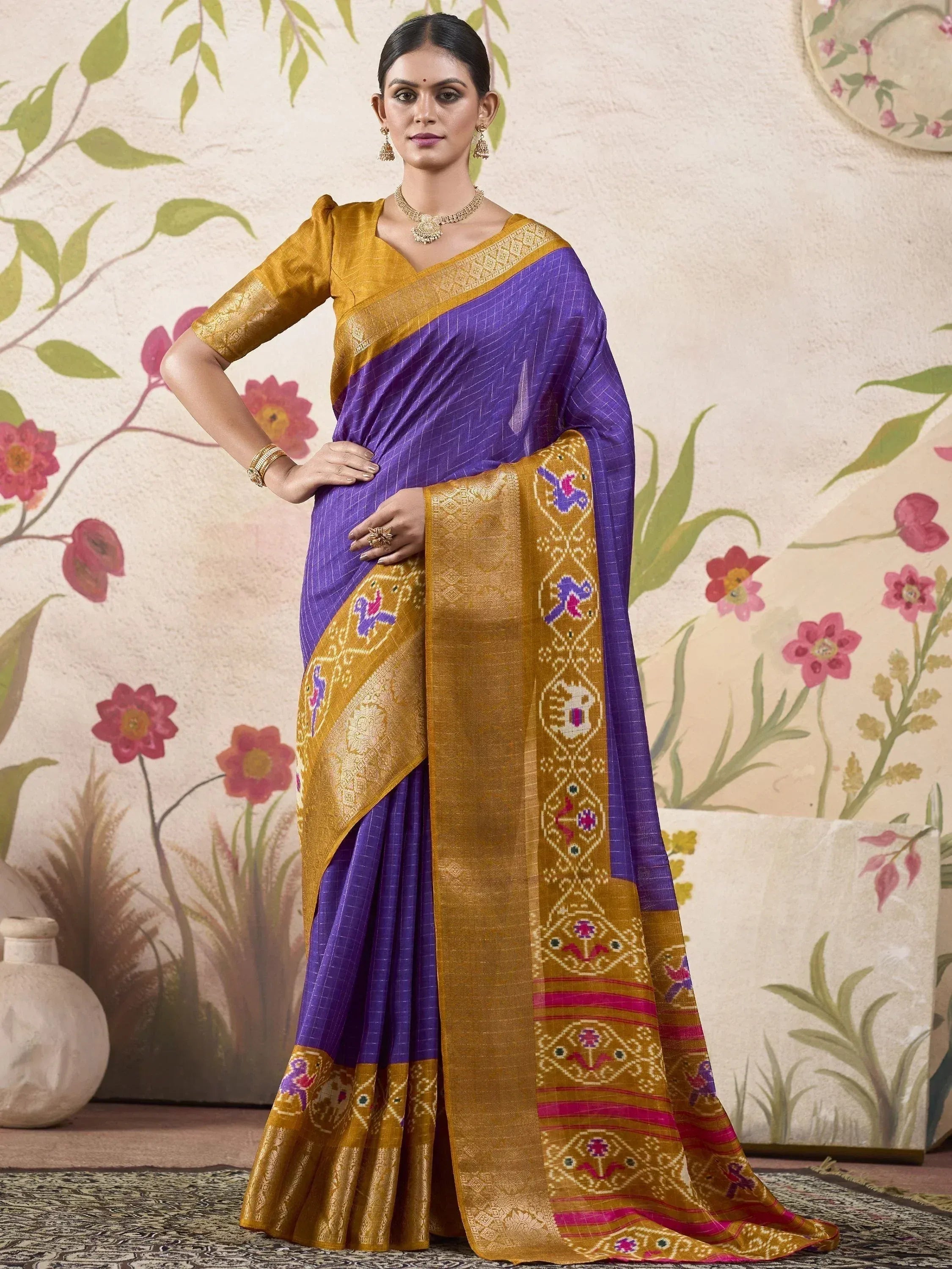 Purple and gold designer saree with intricate embroidery and floral border, perfect for ethnic occasions.