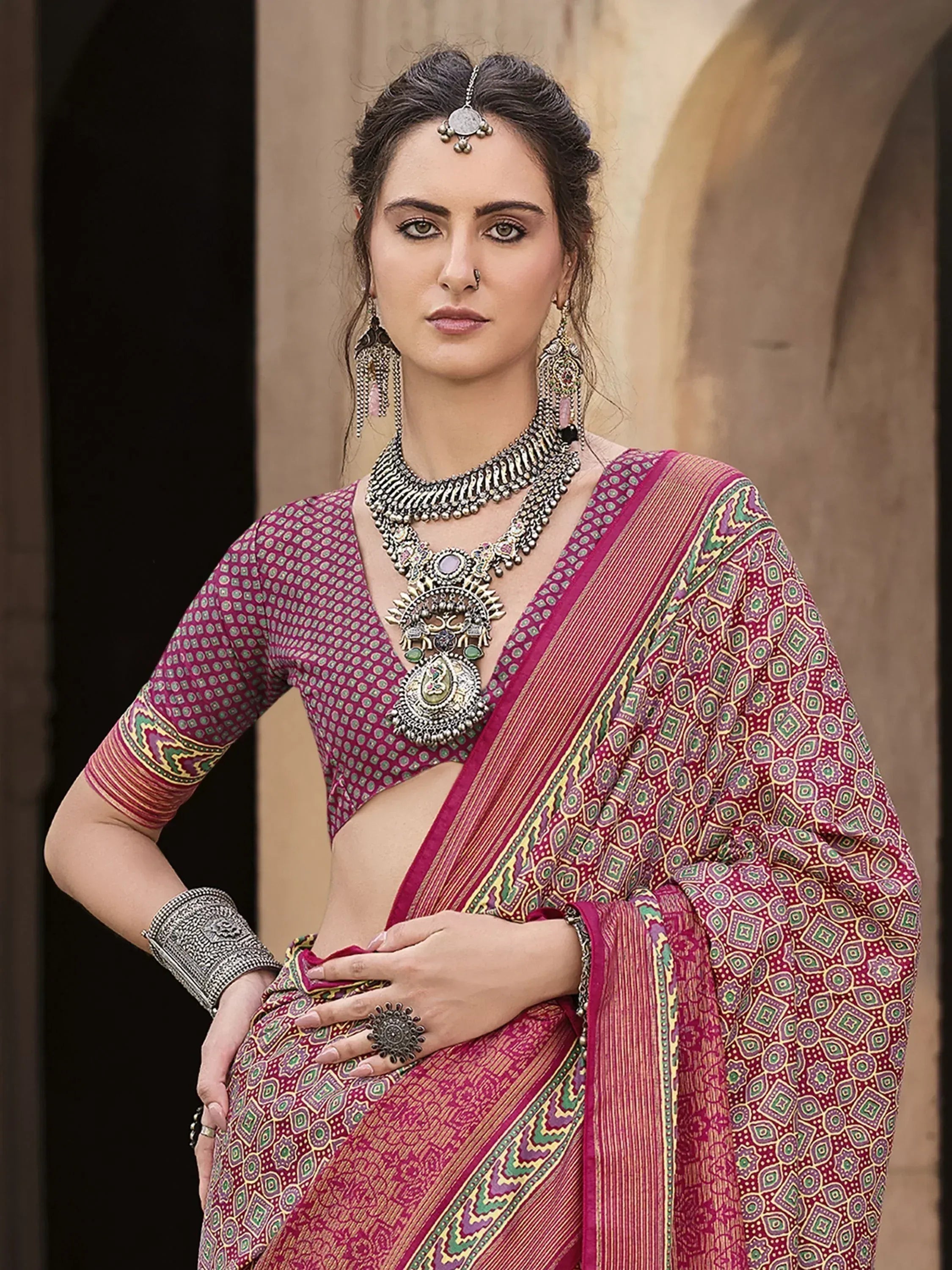Woman in maroon printed saree with ethnic jewelry, traditional Indian attire for festive occasions