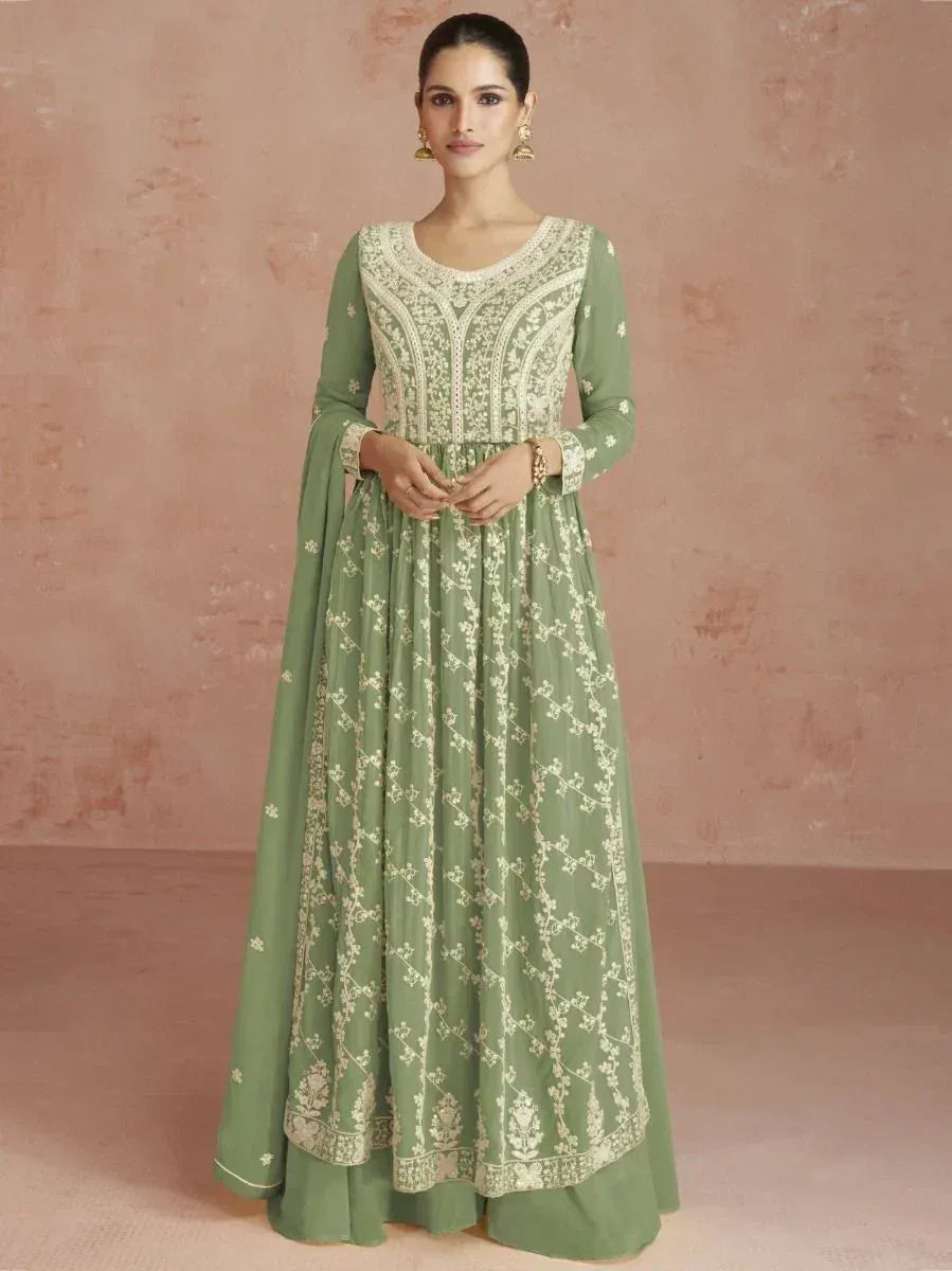 Woman wearing sage green embroidered Anarkali gown with long sleeves and ethnic jewelry