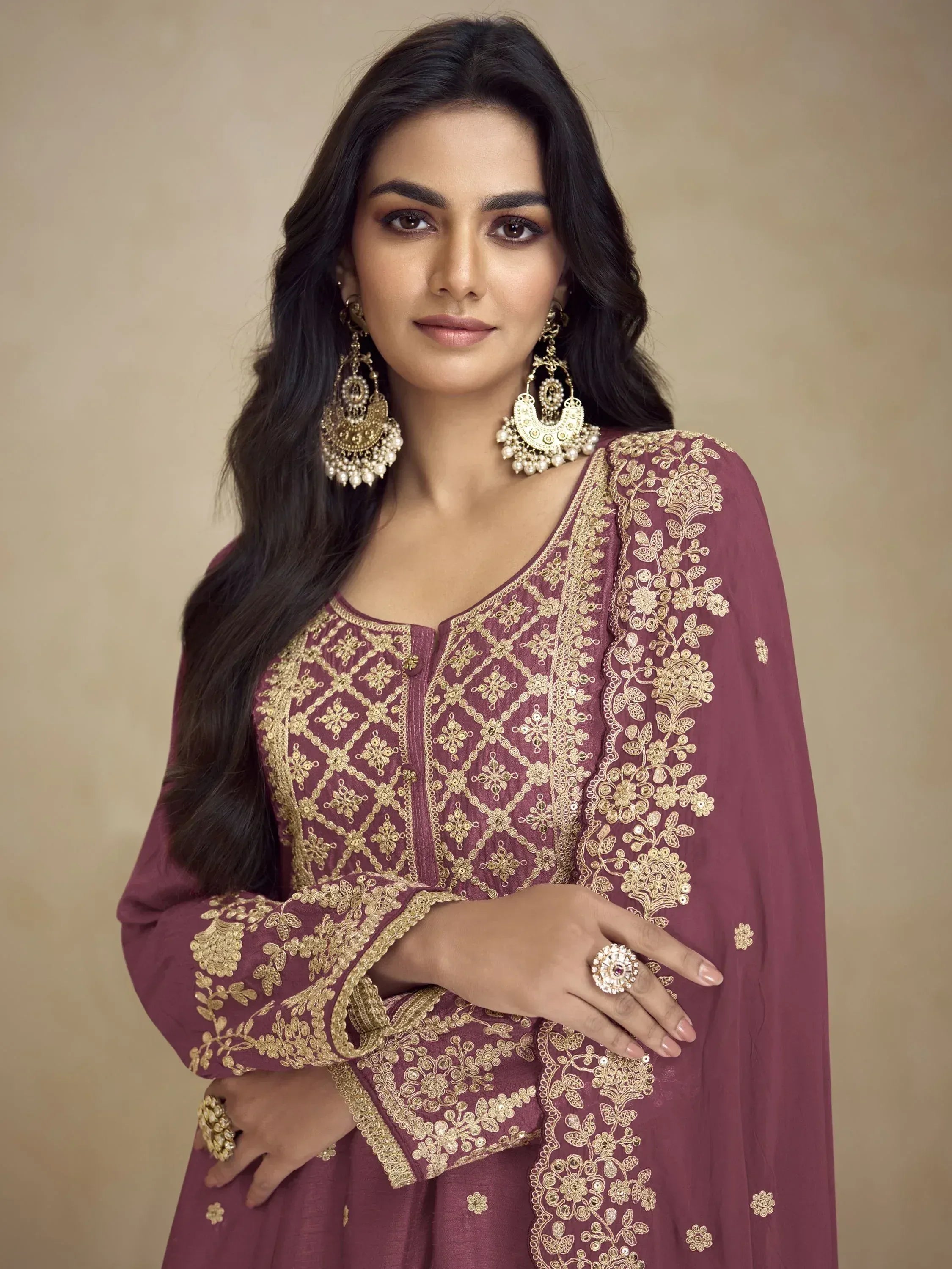 Maroon ethnic gown with gold embroidery, paired with traditional jhumka earrings for Indian festive wear