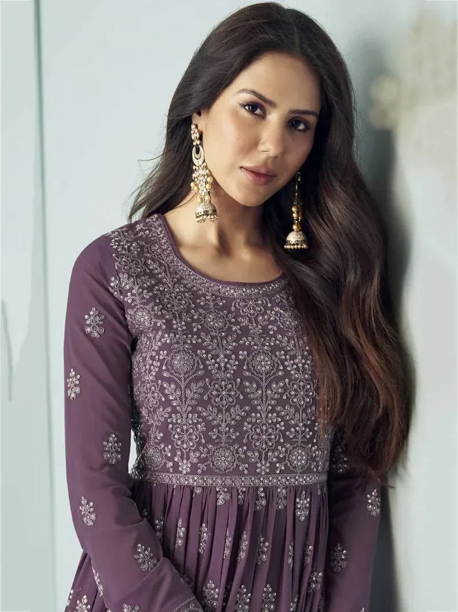 Purple embroidered ethnic gown with floral detailing and gold jhumka earrings