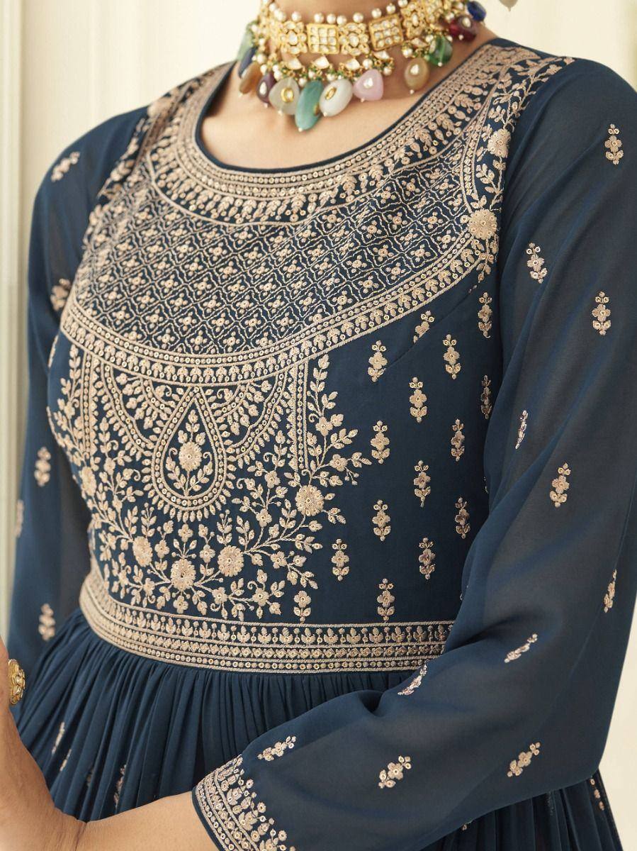 Navy blue ethnic gown with gold floral embroidery and long sleeves, paired with a statement choker necklace