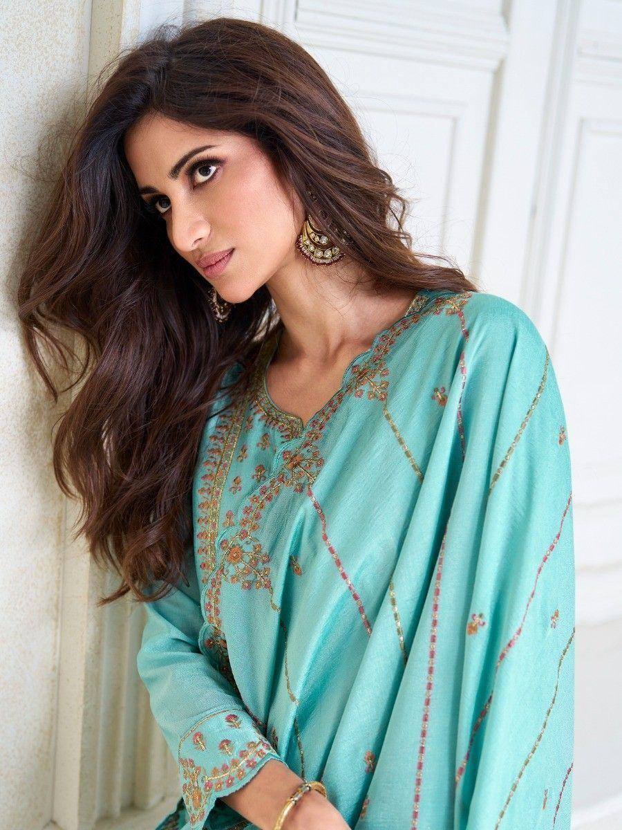 Woman in turquoise embroidered ethnic kurta with gold detailing, styled for Indian wear