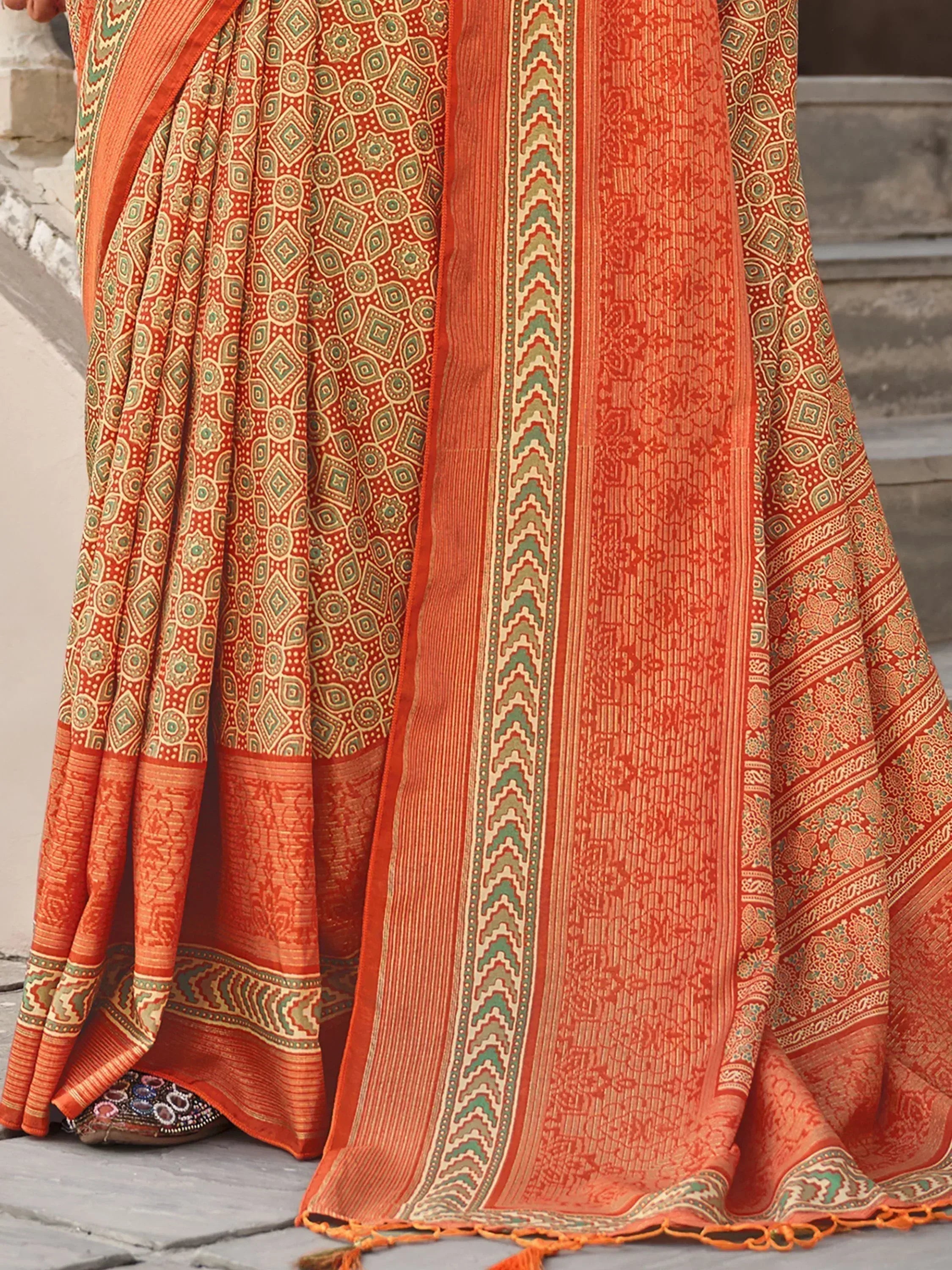 Orange ethnic saree with intricate geometric and floral patterns, traditional Indian wear
