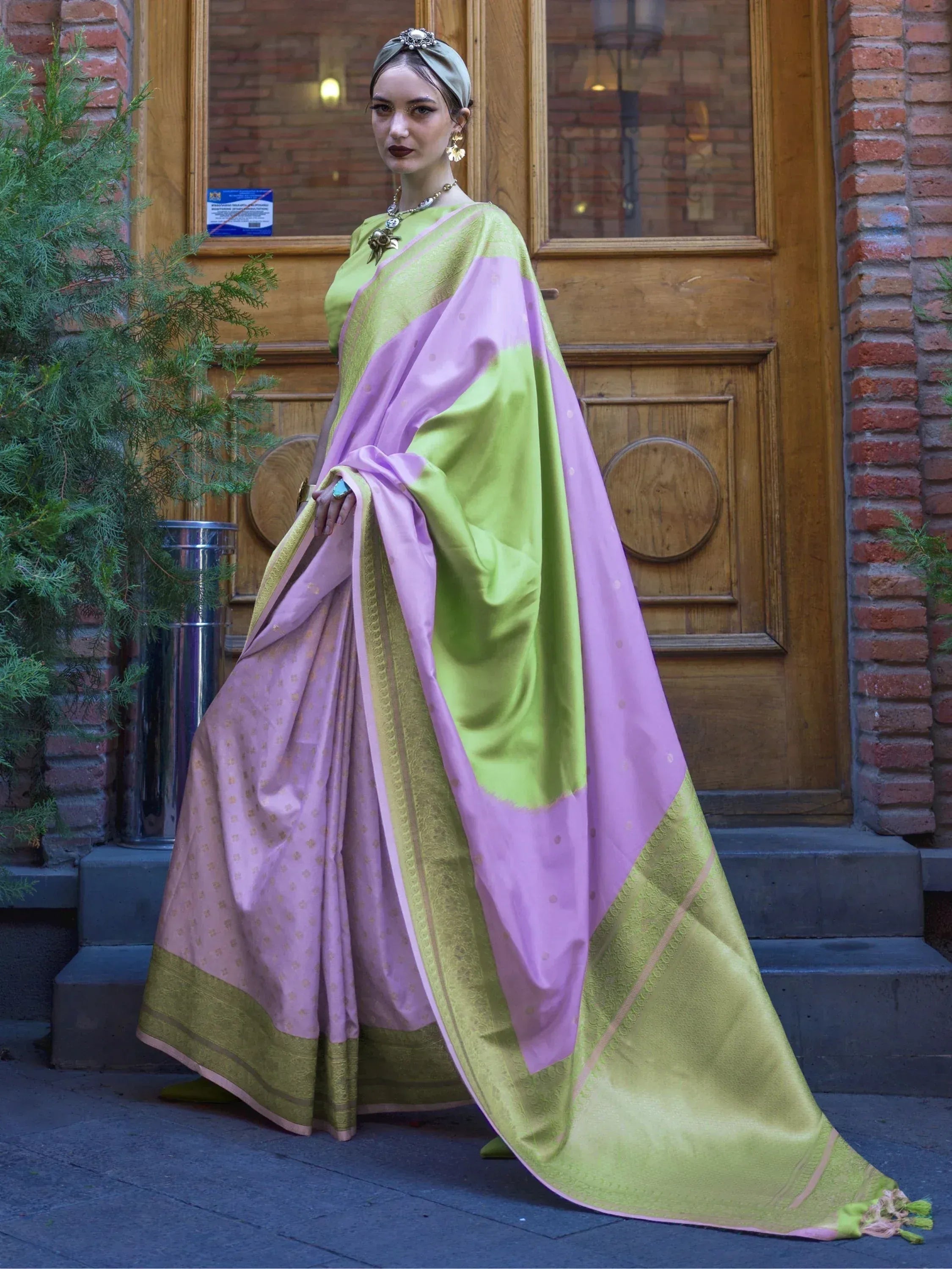 Woman in elegant green and lavender saree with gold border, styled with turban and jewelry for ethnic wear.