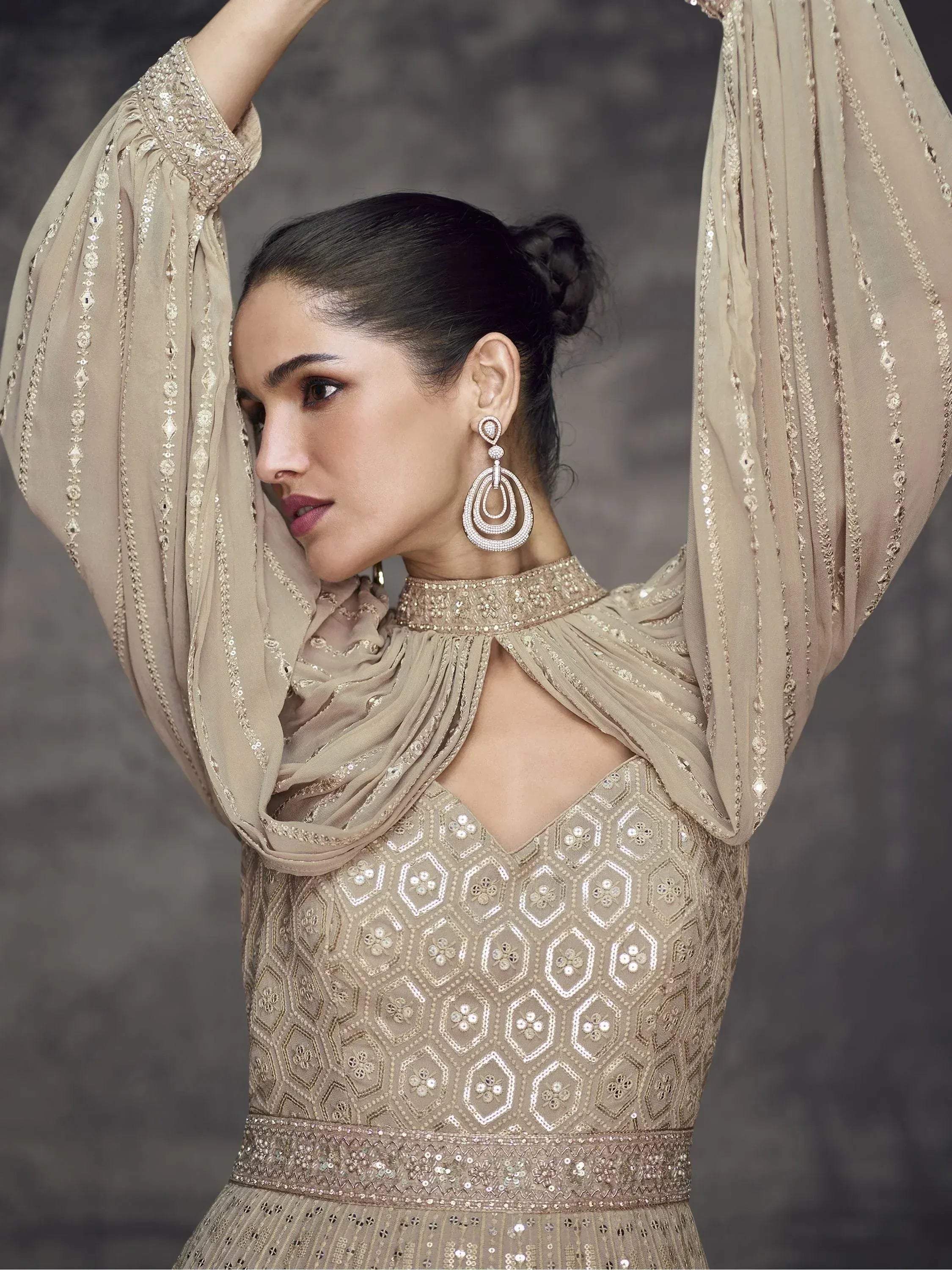 Elegant beige embroidered gown with sequin detailing and statement earrings for ethnic wear