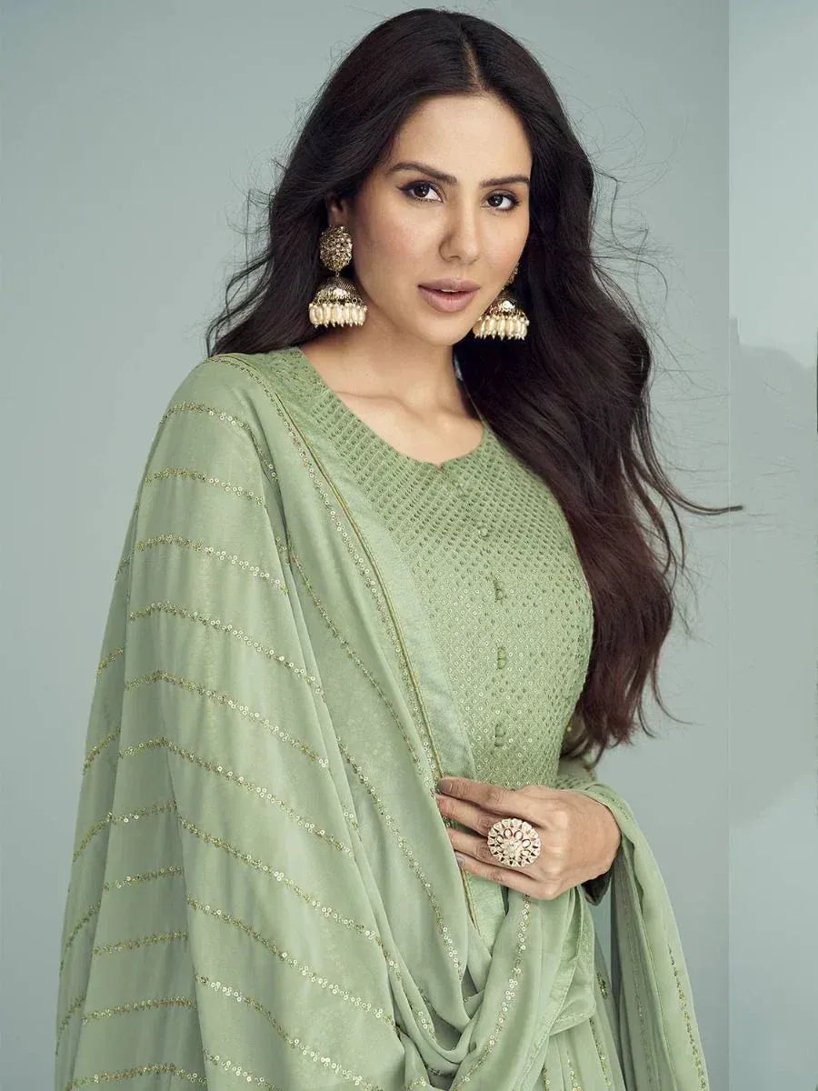 Mint green ethnic salwar kameez with gold embroidery and matching dupatta, styled with jhumka earrings
