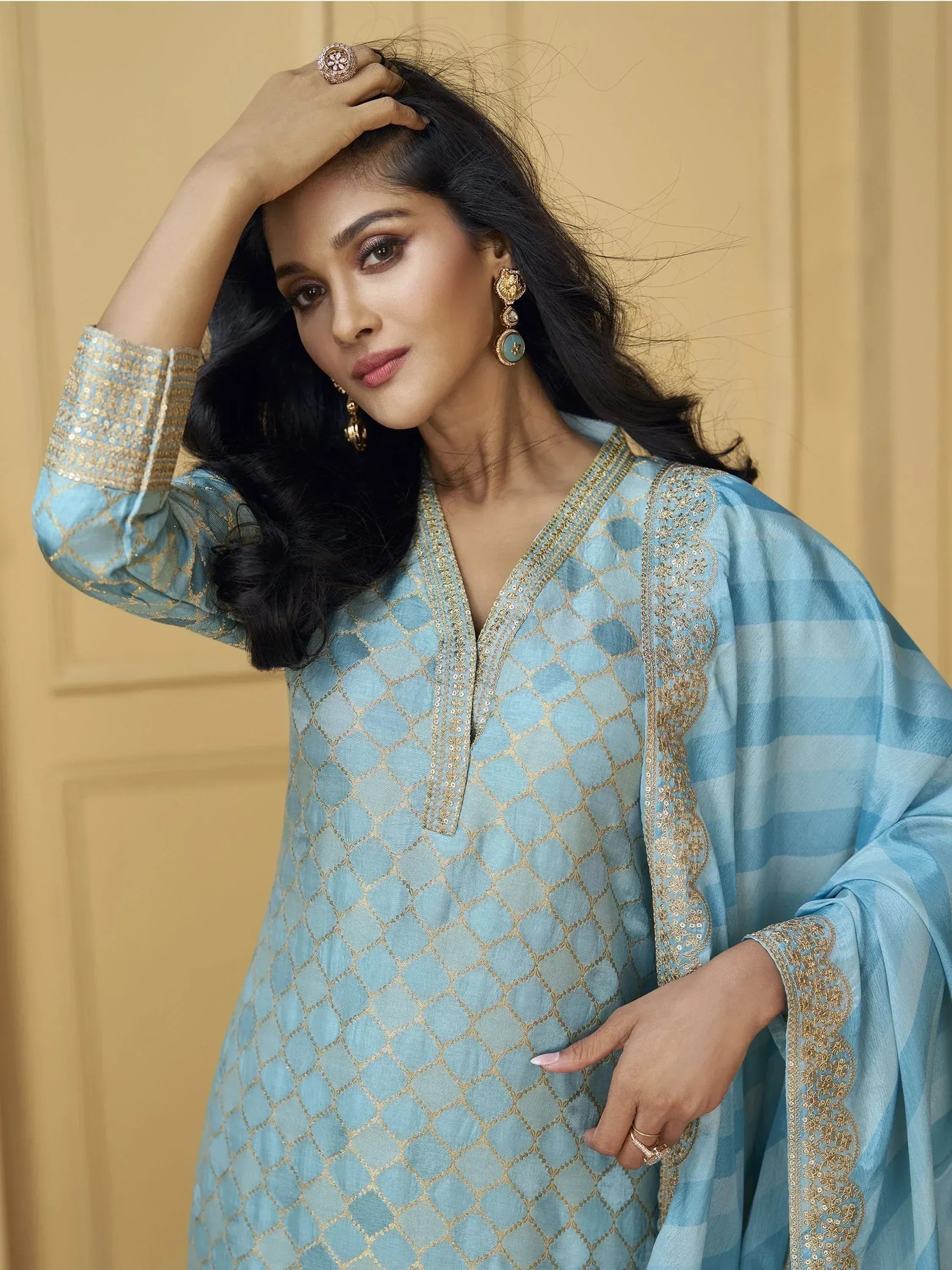 Light blue ethnic kurti with gold embroidery and matching dupatta, styled with statement earrings for festive occasions.