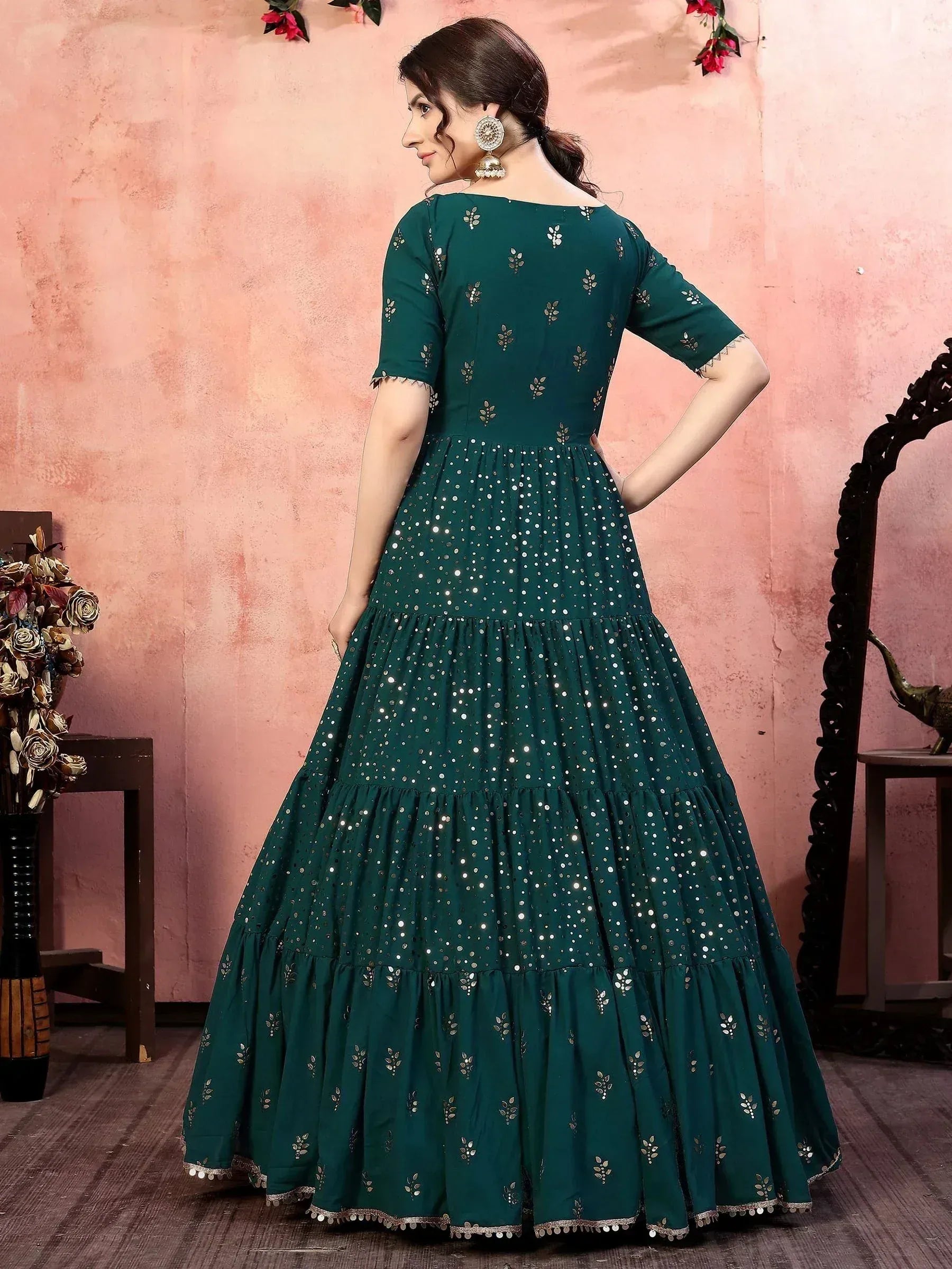 Emerald green ethnic gown with mirror work and tiered skirt, perfect for Indian festive occasions