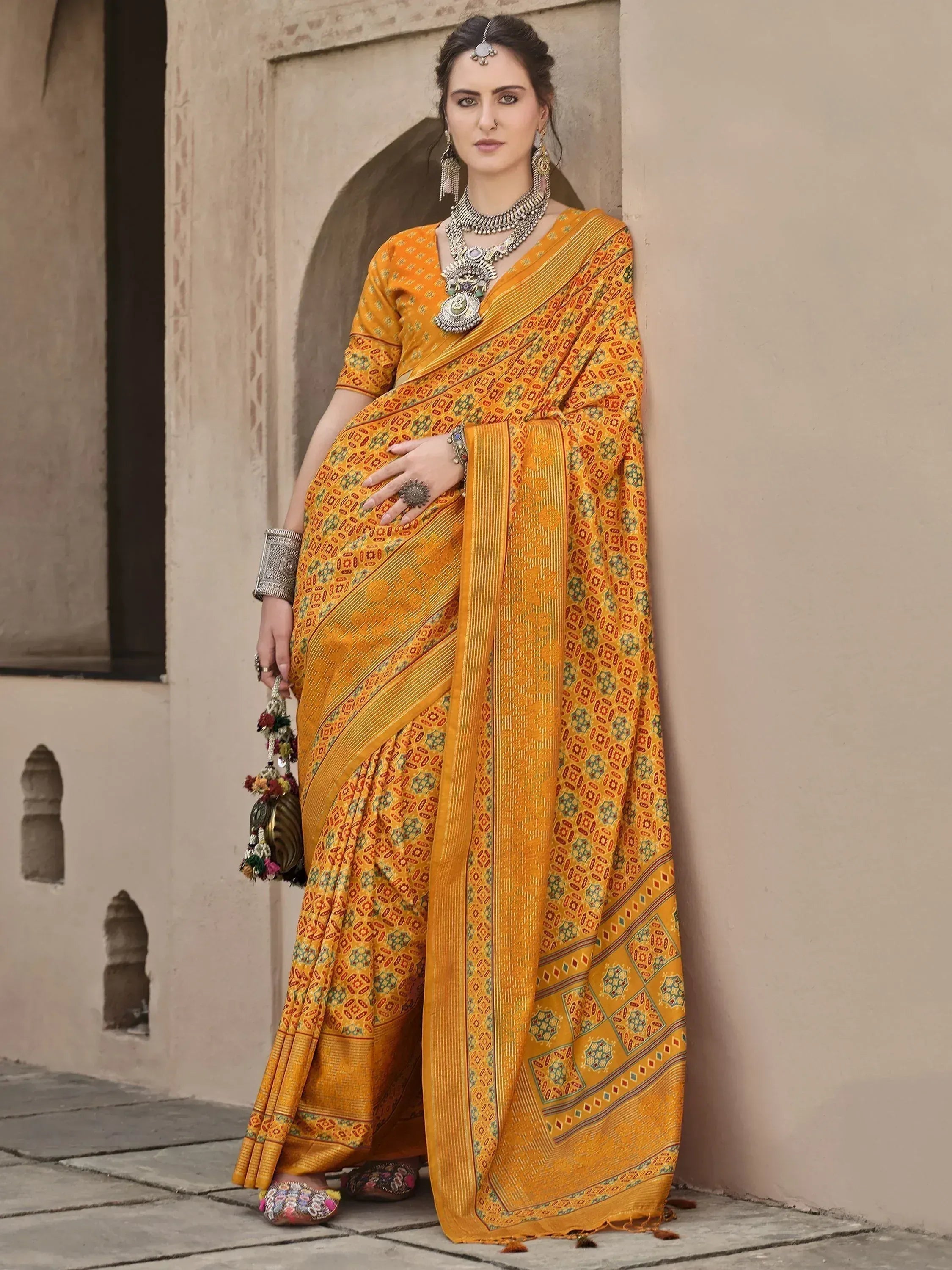 Yellow printed saree with ethnic jewelry, perfect for Indian occasions and festive wear