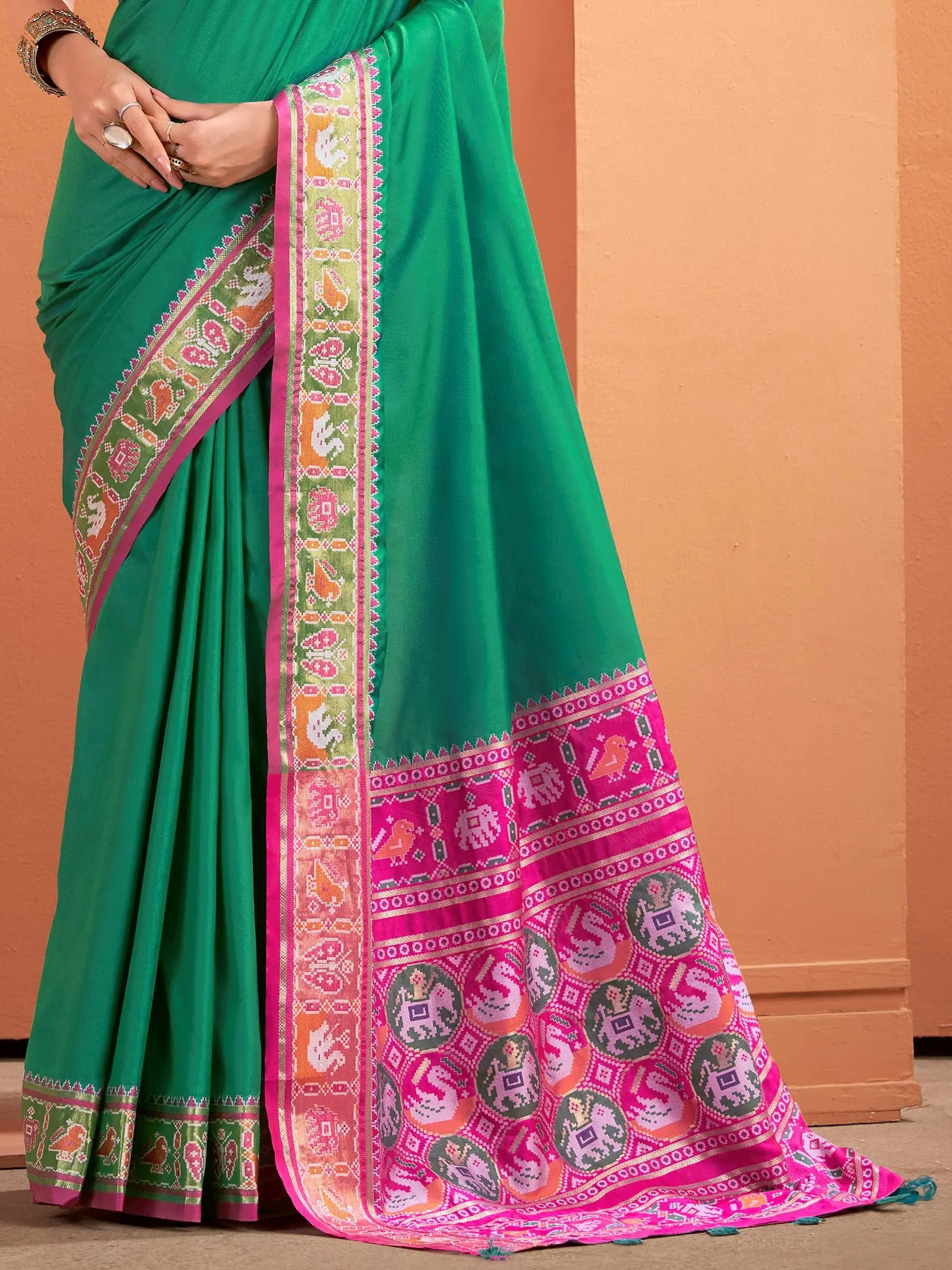Green saree with pink and multicolor elephant motifs, perfect for ethnic occasions