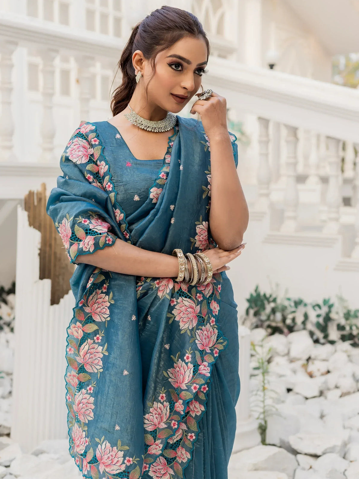 Teal blue embroidered saree with pink floral design, perfect for Indian ethnic wear occasions.