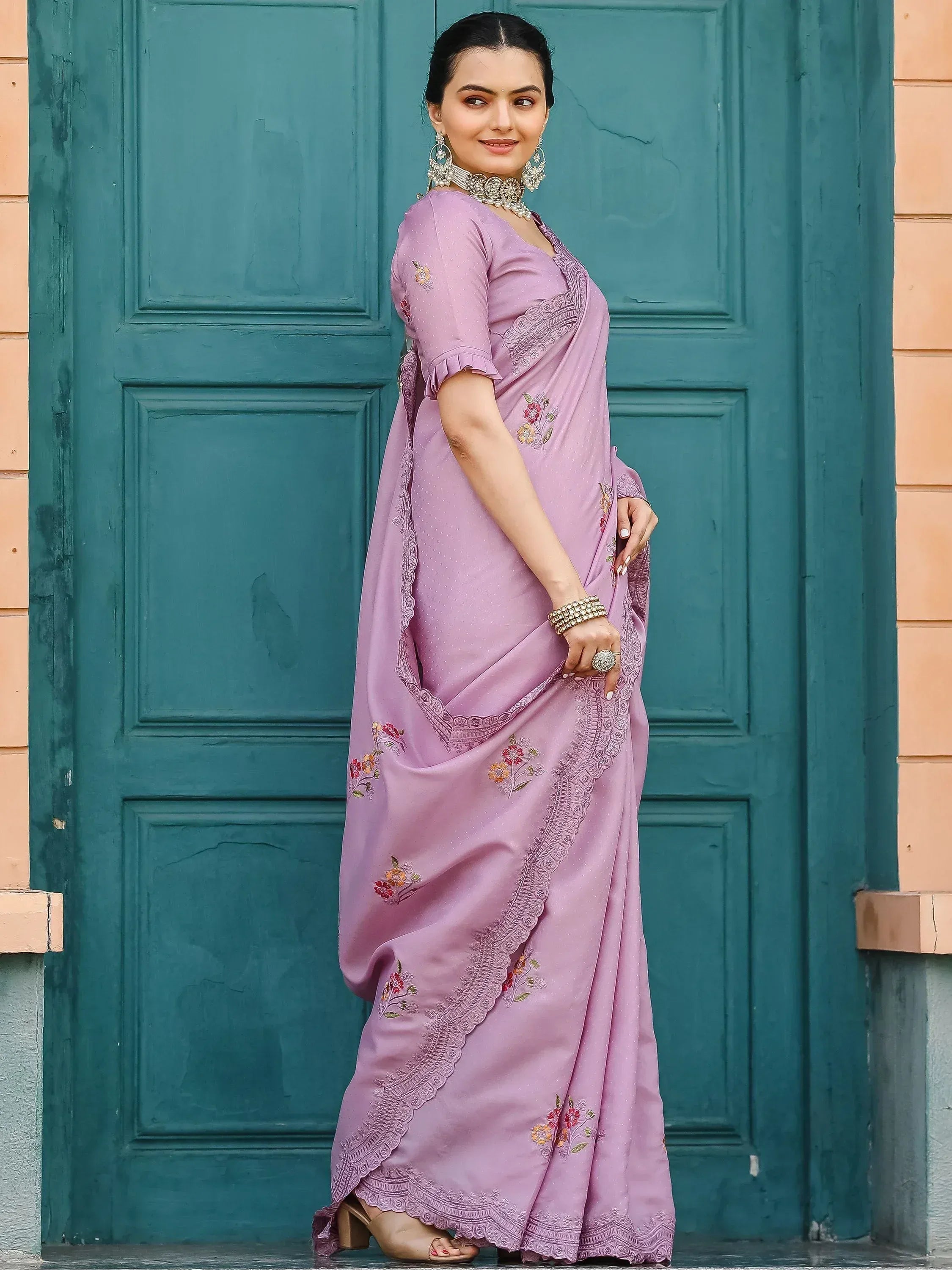 Lavender embroidered saree with floral motifs and lace border, styled with traditional jewelry