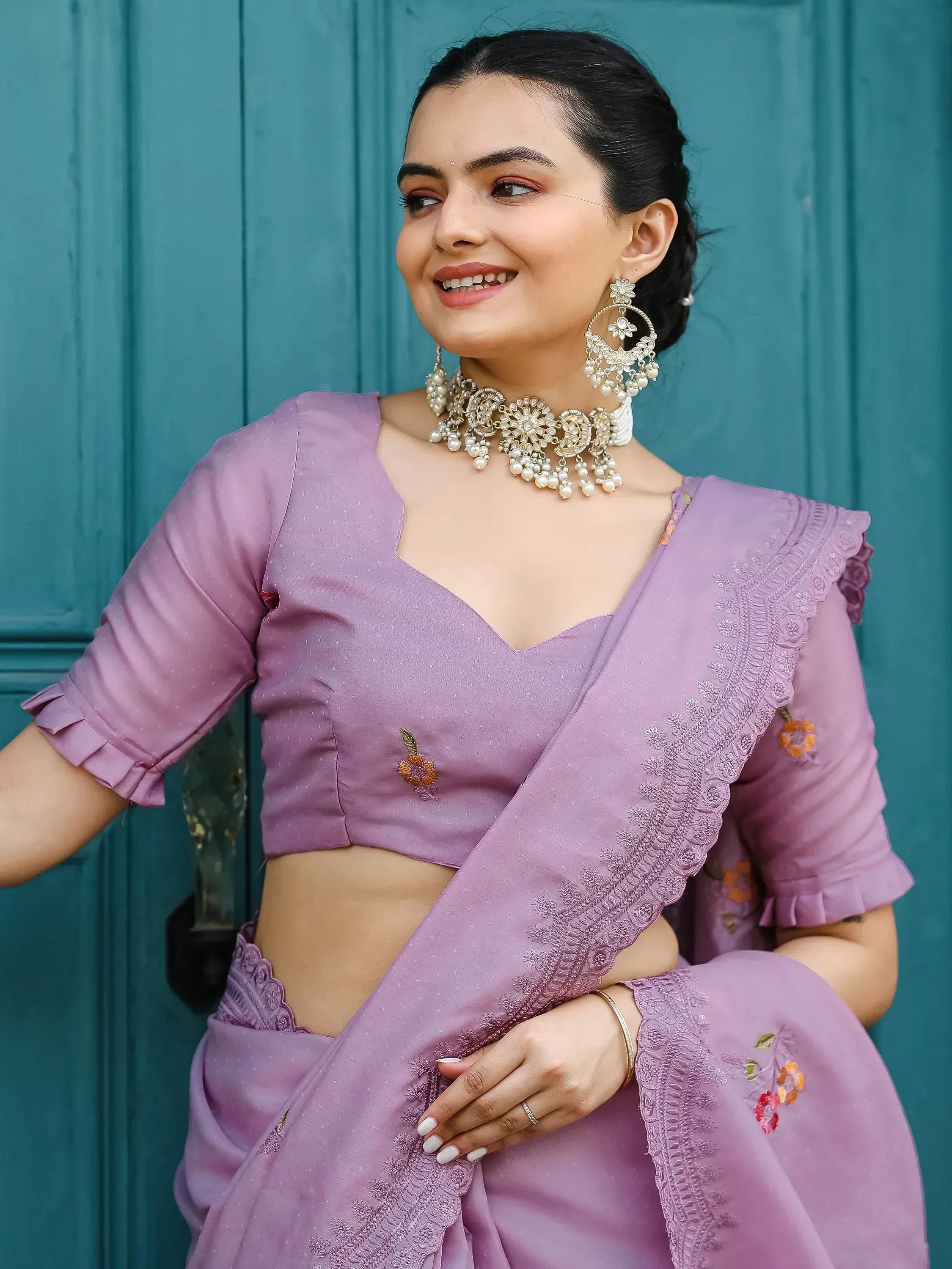 Woman in lavender embroidered saree with floral details and statement jewelry, perfect for Indian ethnic occasions.