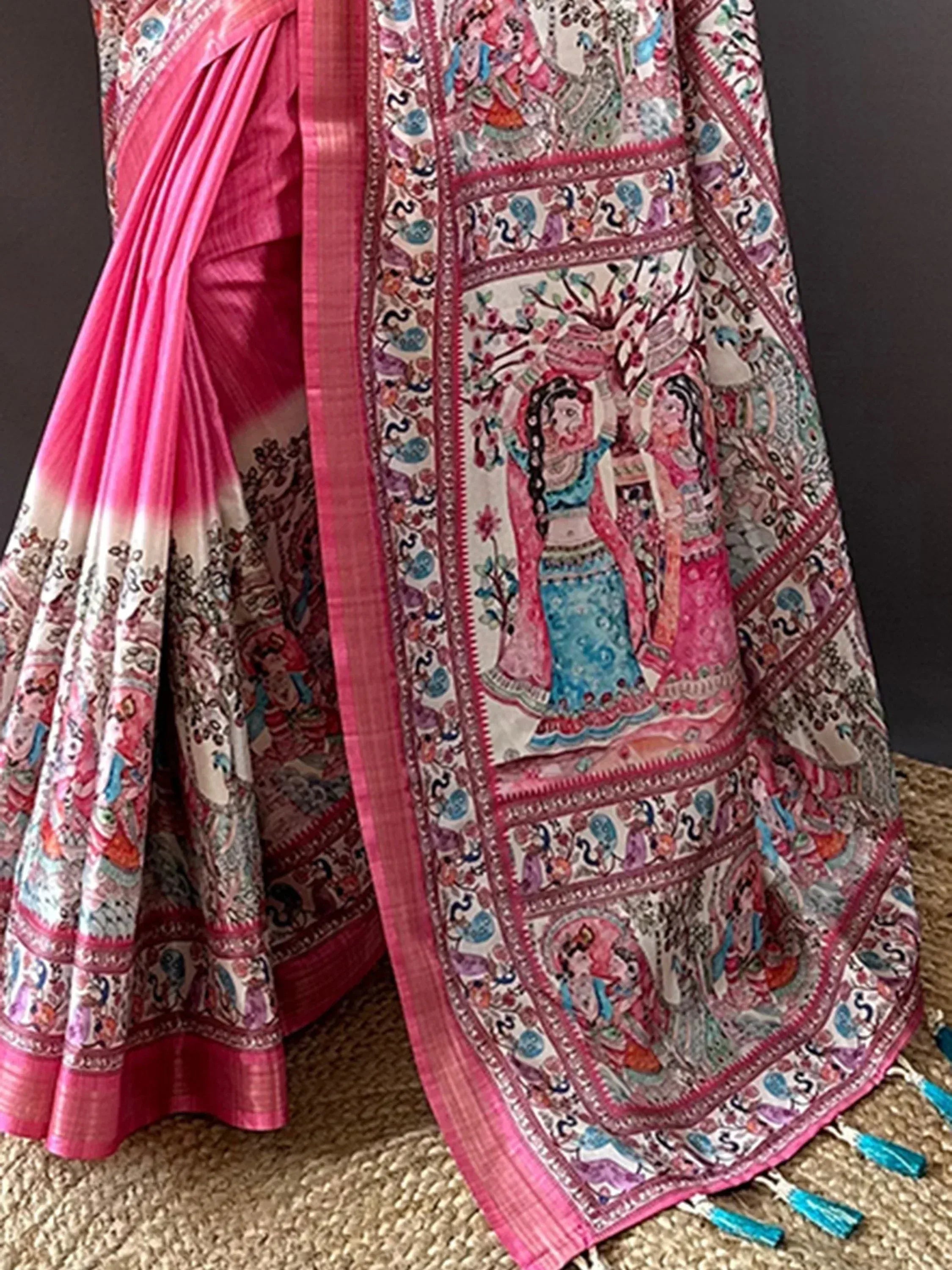 Pink and white printed saree with intricate folk art designs and tassels, ideal for ethnic wear