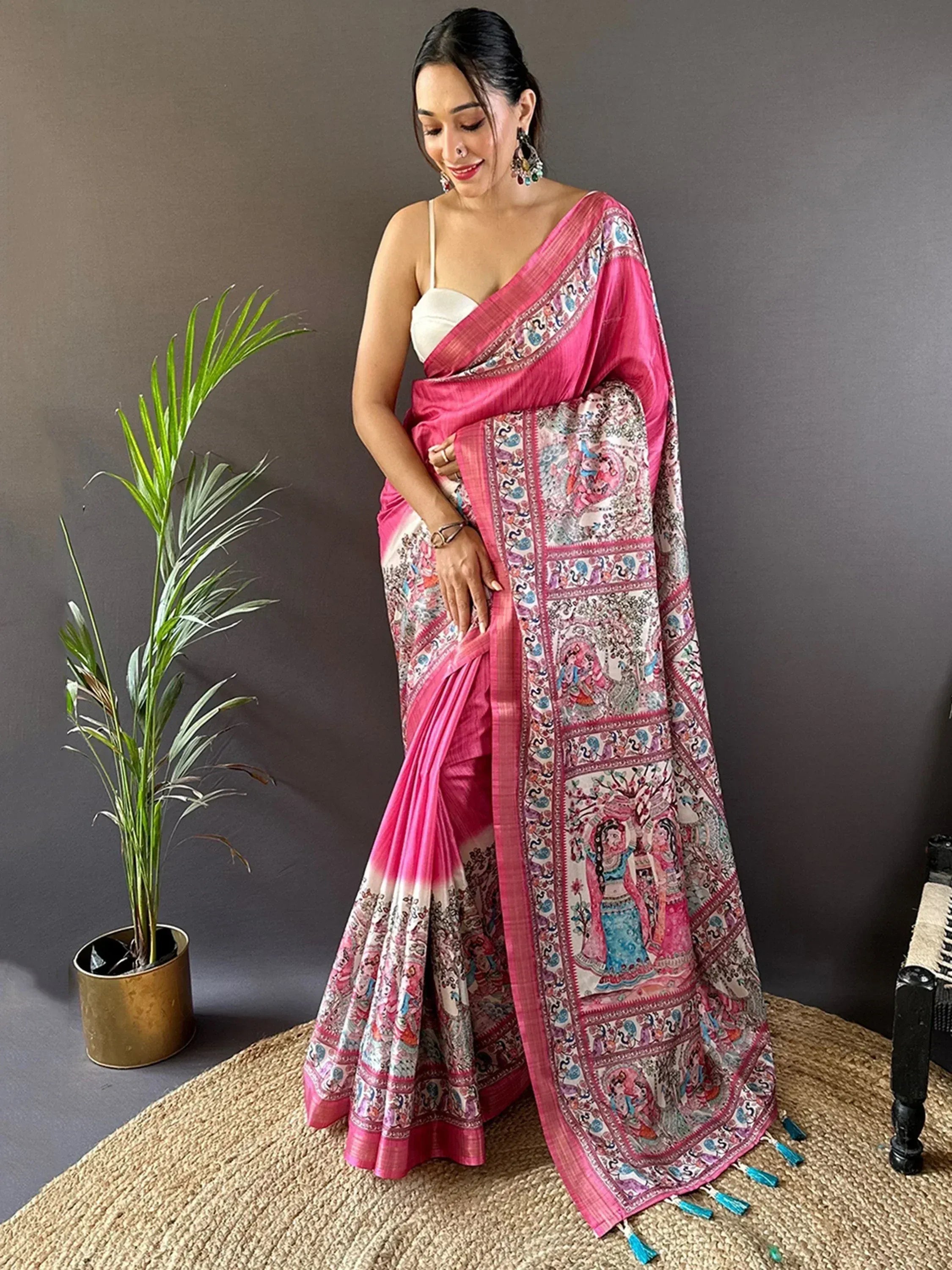 Pink printed saree with ethnic motifs and tassels, styled with white blouse for Indian festive wear