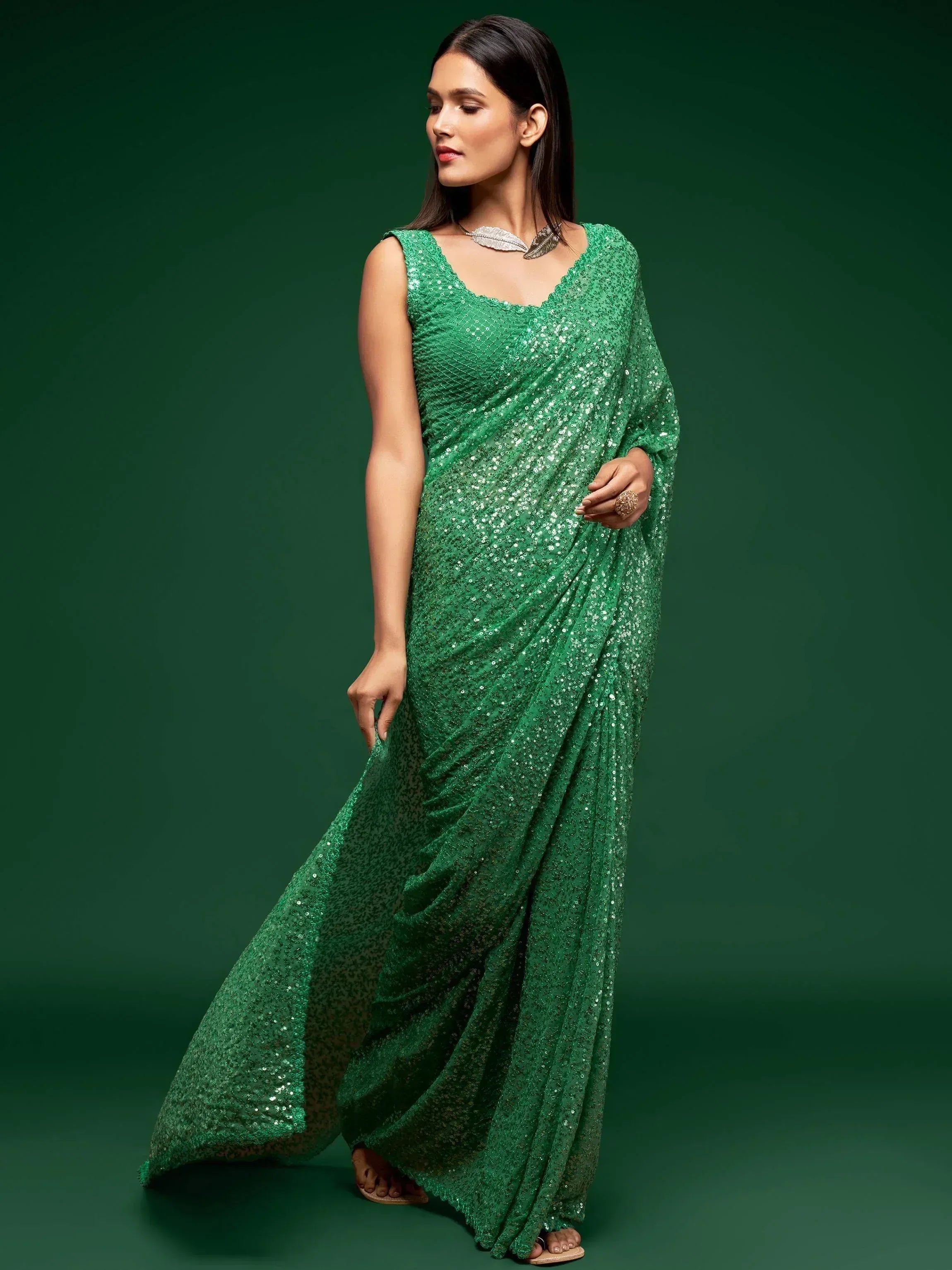 Emerald green sequin saree with sleeveless blouse, perfect for Indian ethnic wear and festive occasions.