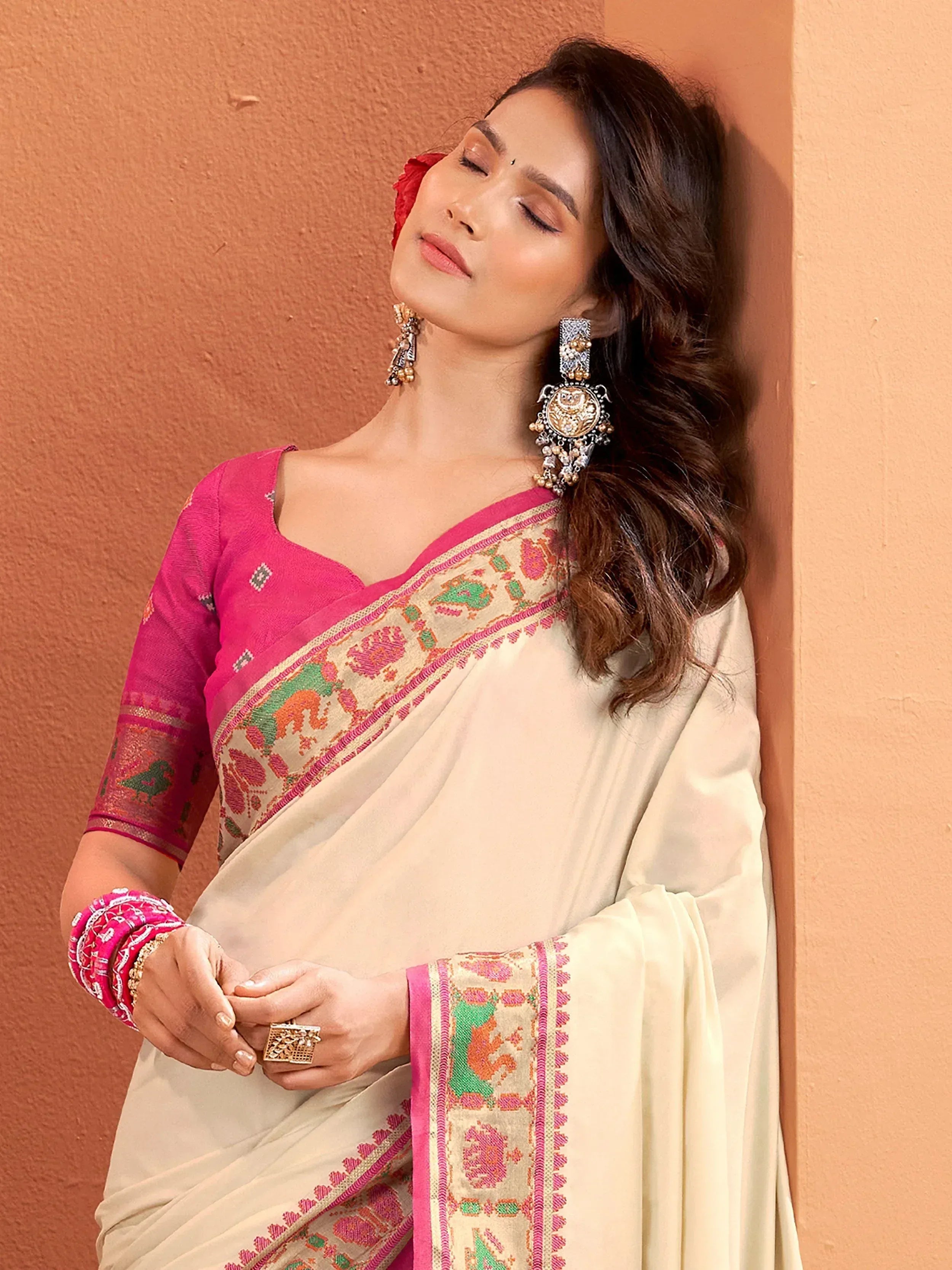Elegant cream saree with pink and green embroidery, paired with designer blouse and jhumka earrings