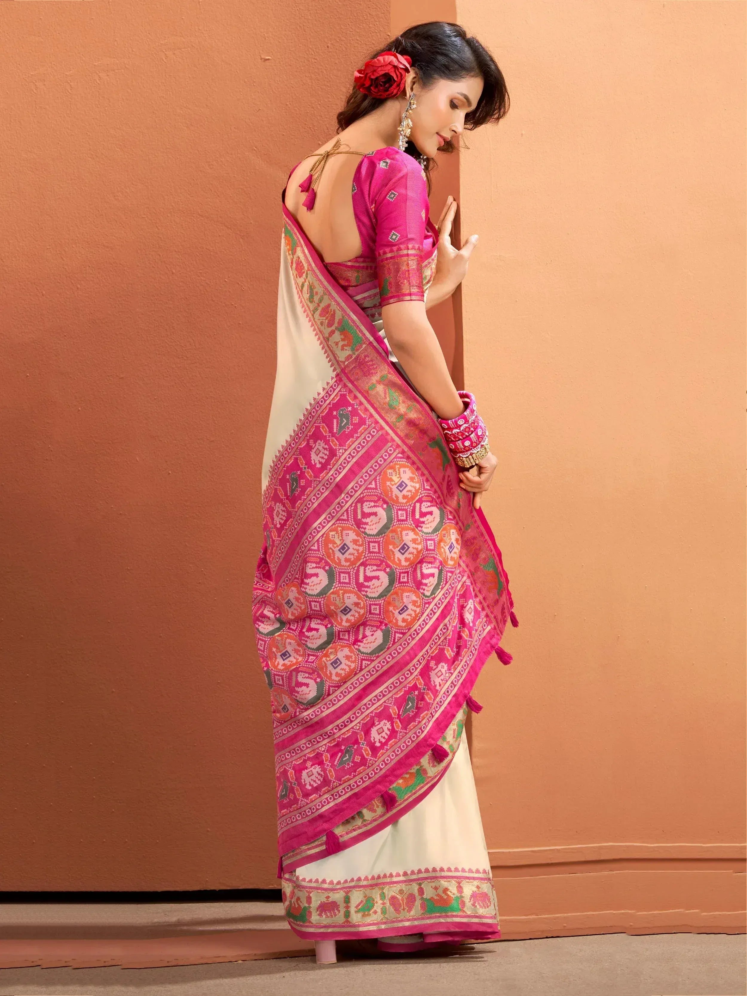 Woman in vibrant pink and cream ethnic saree with elephant print, perfect for Indian festivals and occasions.