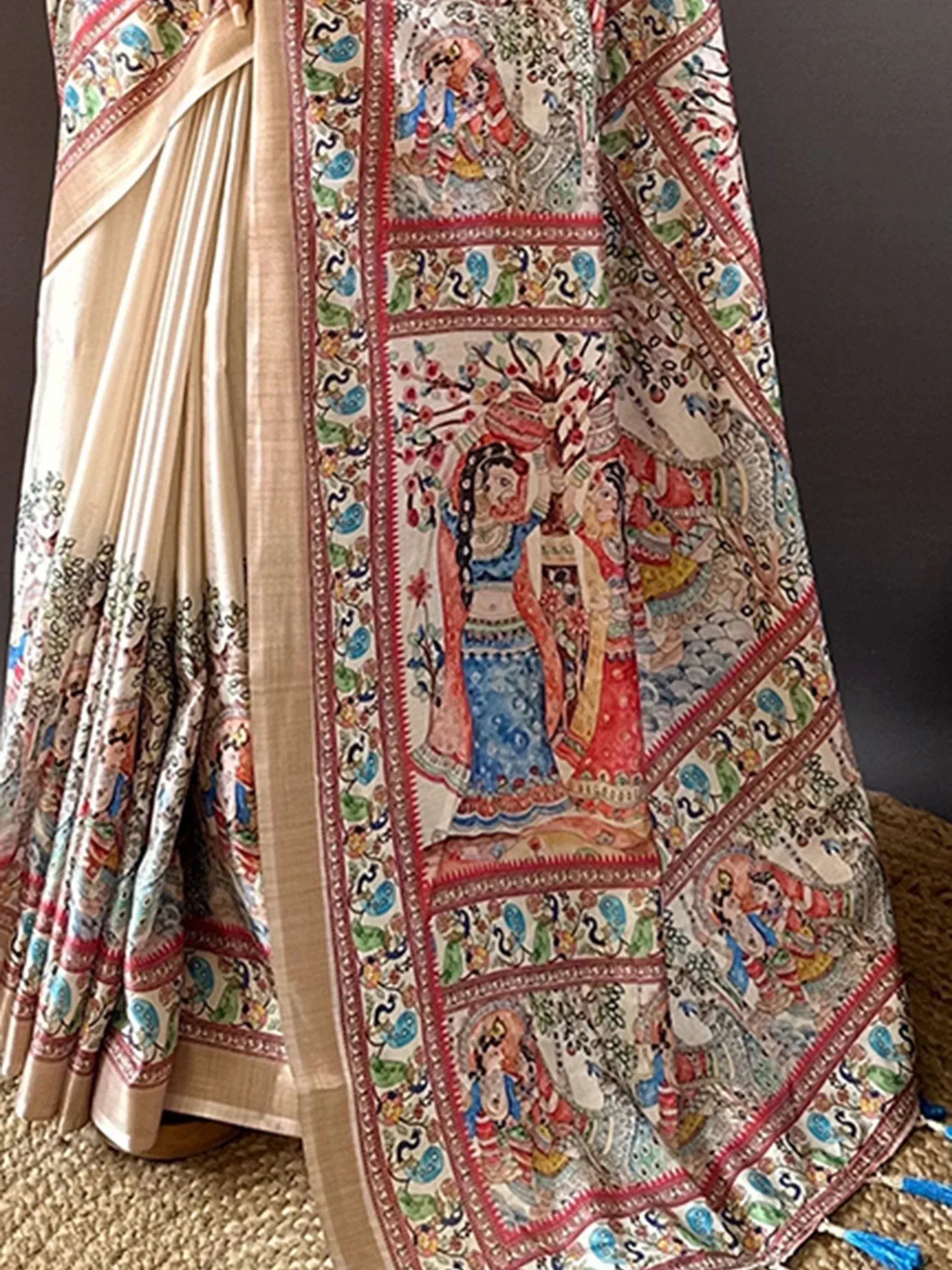 Cream saree with colorful hand-painted Indian motifs and traditional border design