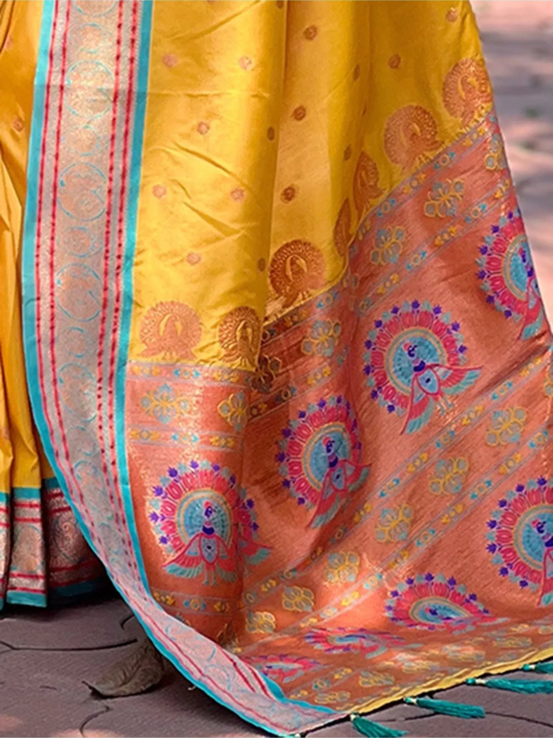 Yellow and peach ethnic saree with peacock motifs, floral border, and tassels for Indian occasions