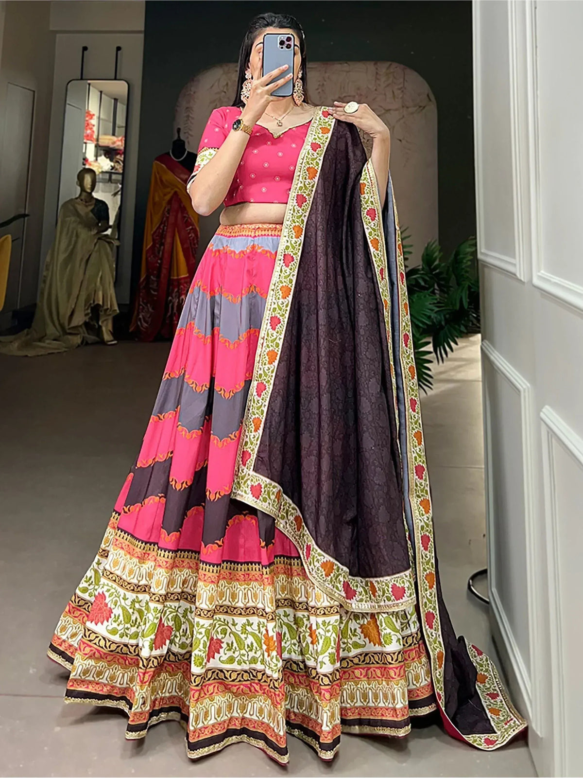 Woman in vibrant pink and purple printed lehenga choli with floral dupatta, ethnic Indian wear