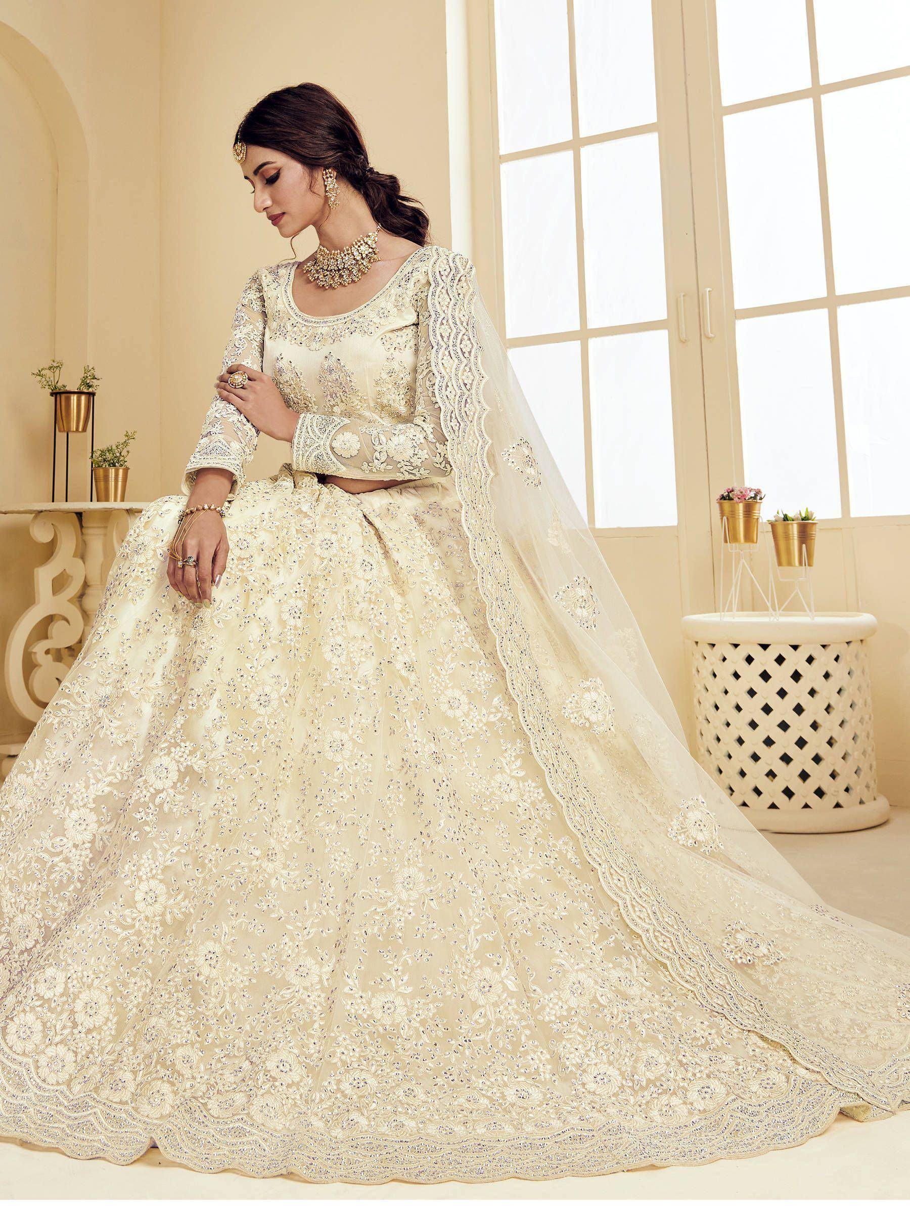 Elegant ivory designer lehenga choli with heavy embroidery and lace dupatta, perfect for Indian weddings