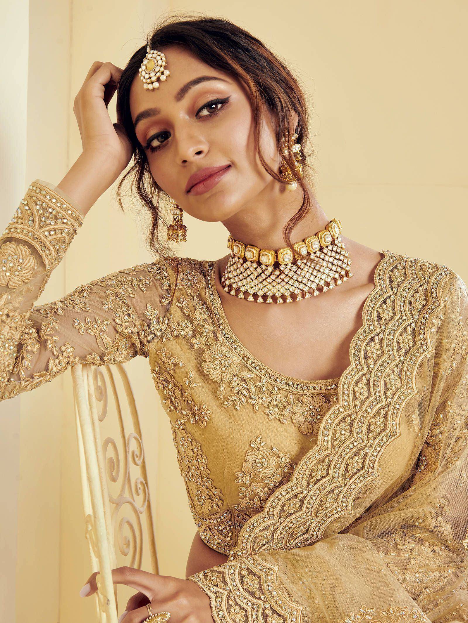 Elegant gold embroidered Indian ethnic wear with matching jewelry for weddings and festivals