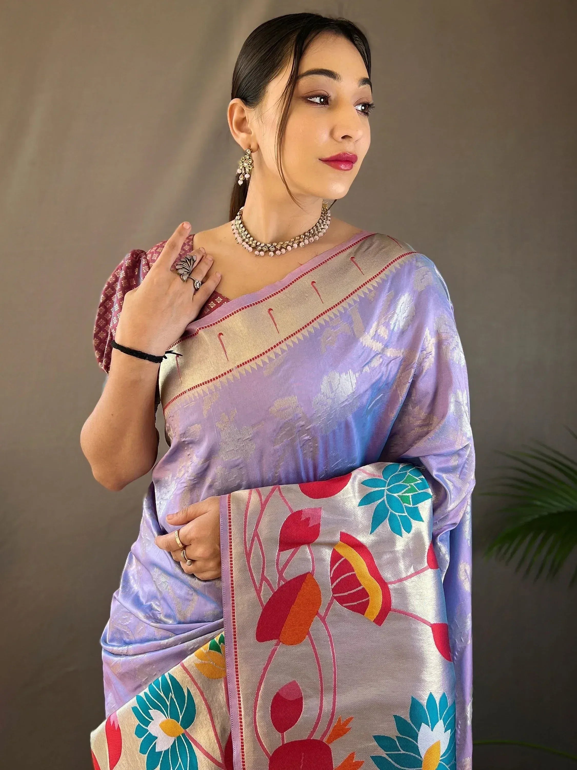 Woman in elegant purple saree with floral border, perfect for Indian ethnic wear occasions.
