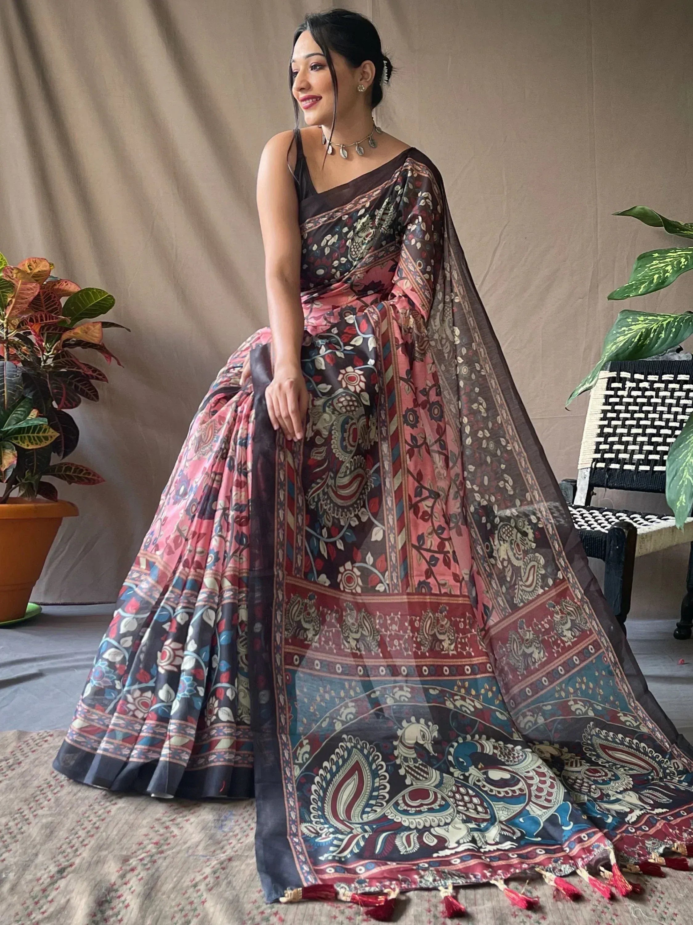 Woman in printed ethnic saree with peacock motifs, floral patterns, and tassels, styled for Indian occasions