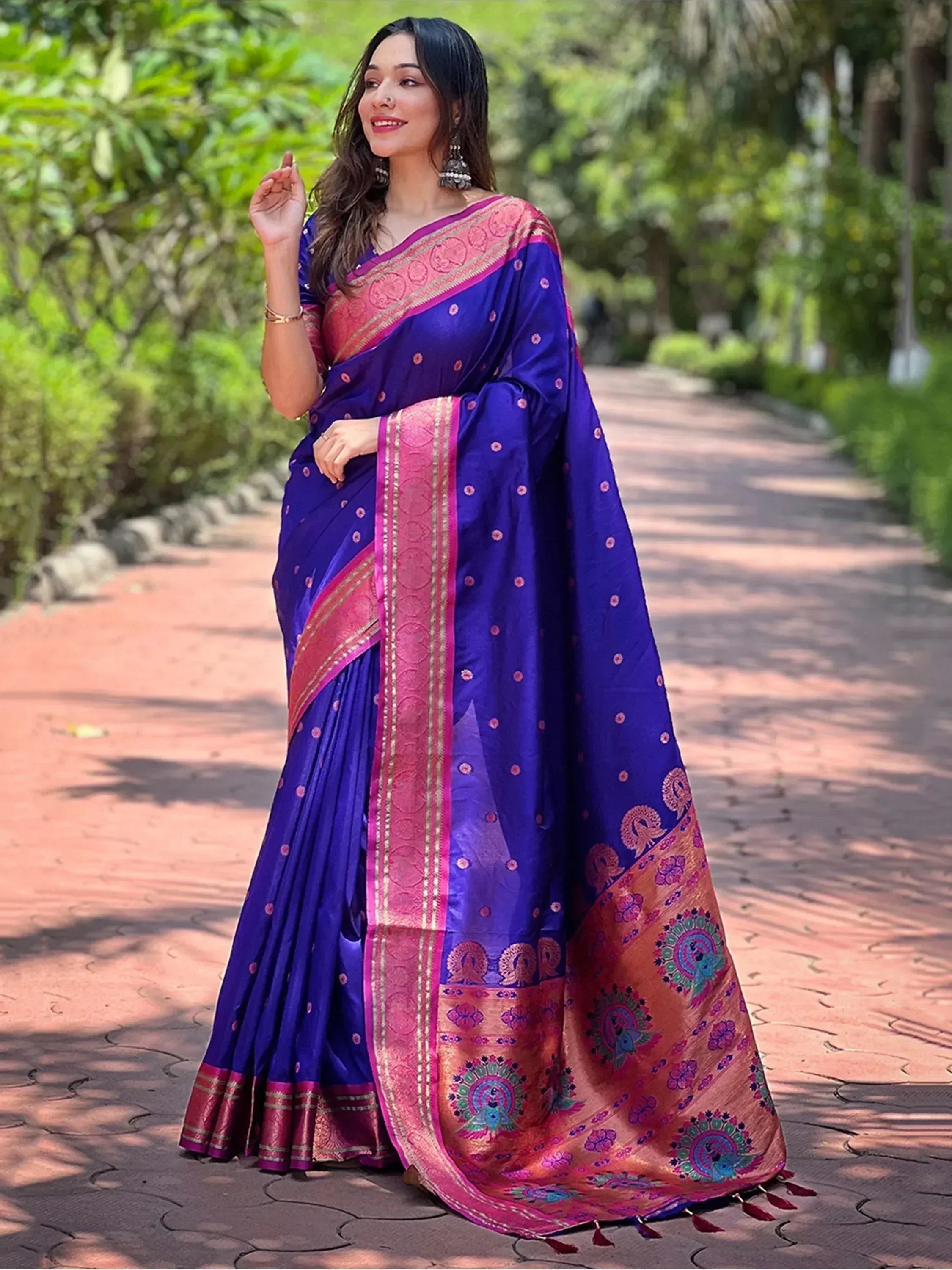 Woman in vibrant blue and pink ethnic saree with peacock motifs, perfect for Indian occasions