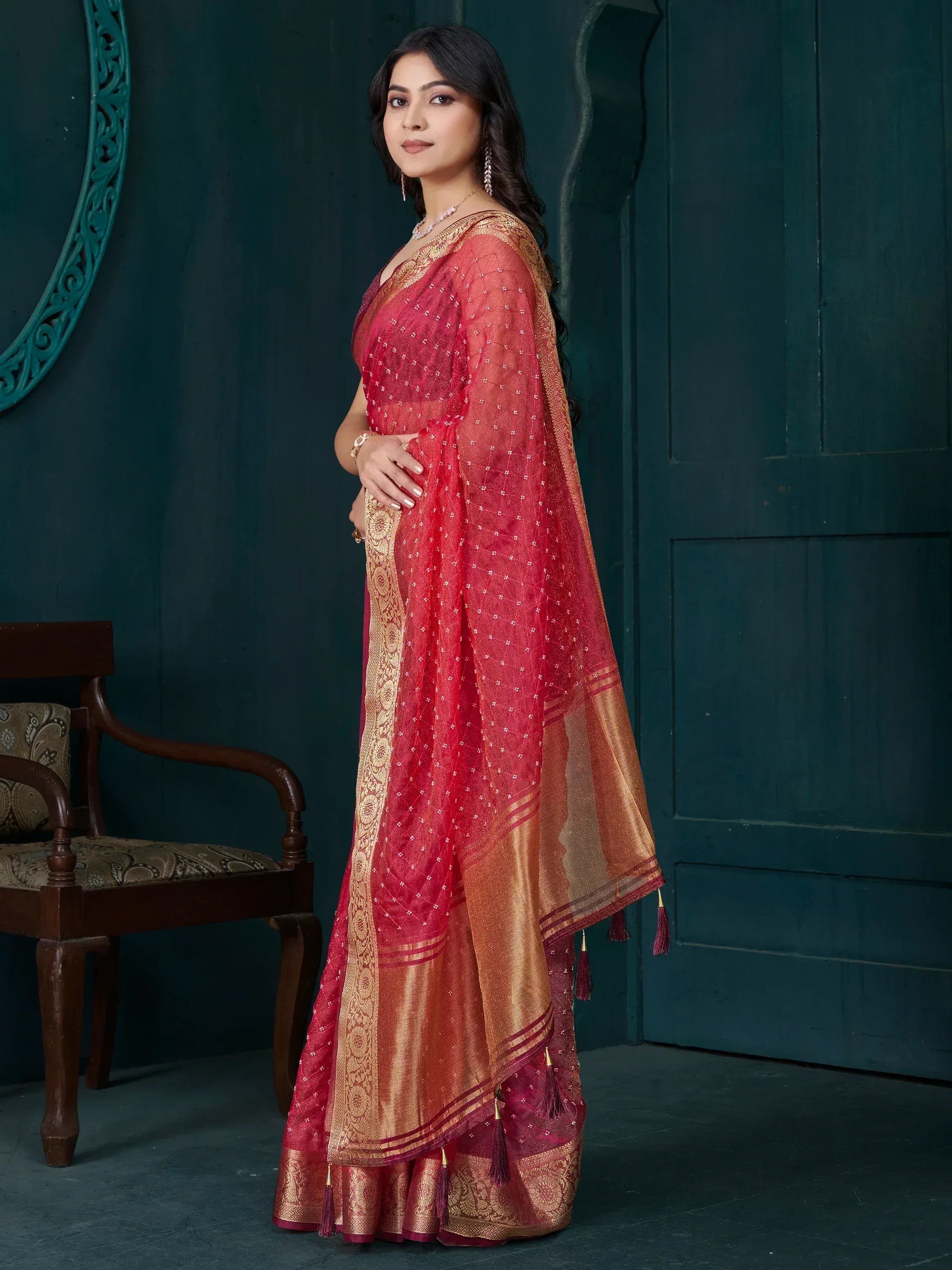 Elegant red and gold saree with intricate embroidery and tassels, perfect for Indian ethnic wear.