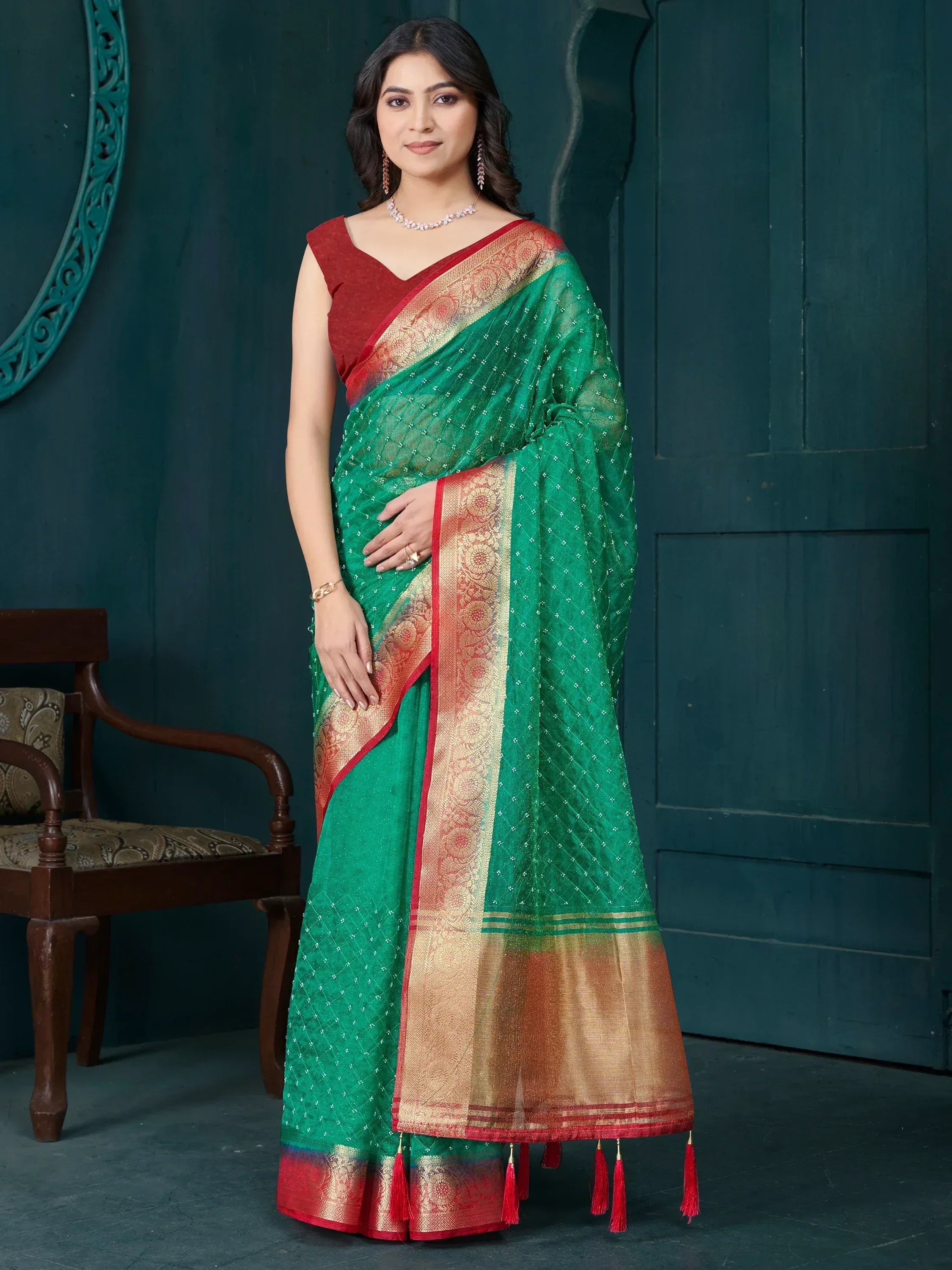 Green and red designer saree with golden border and tassels, perfect for ethnic occasions