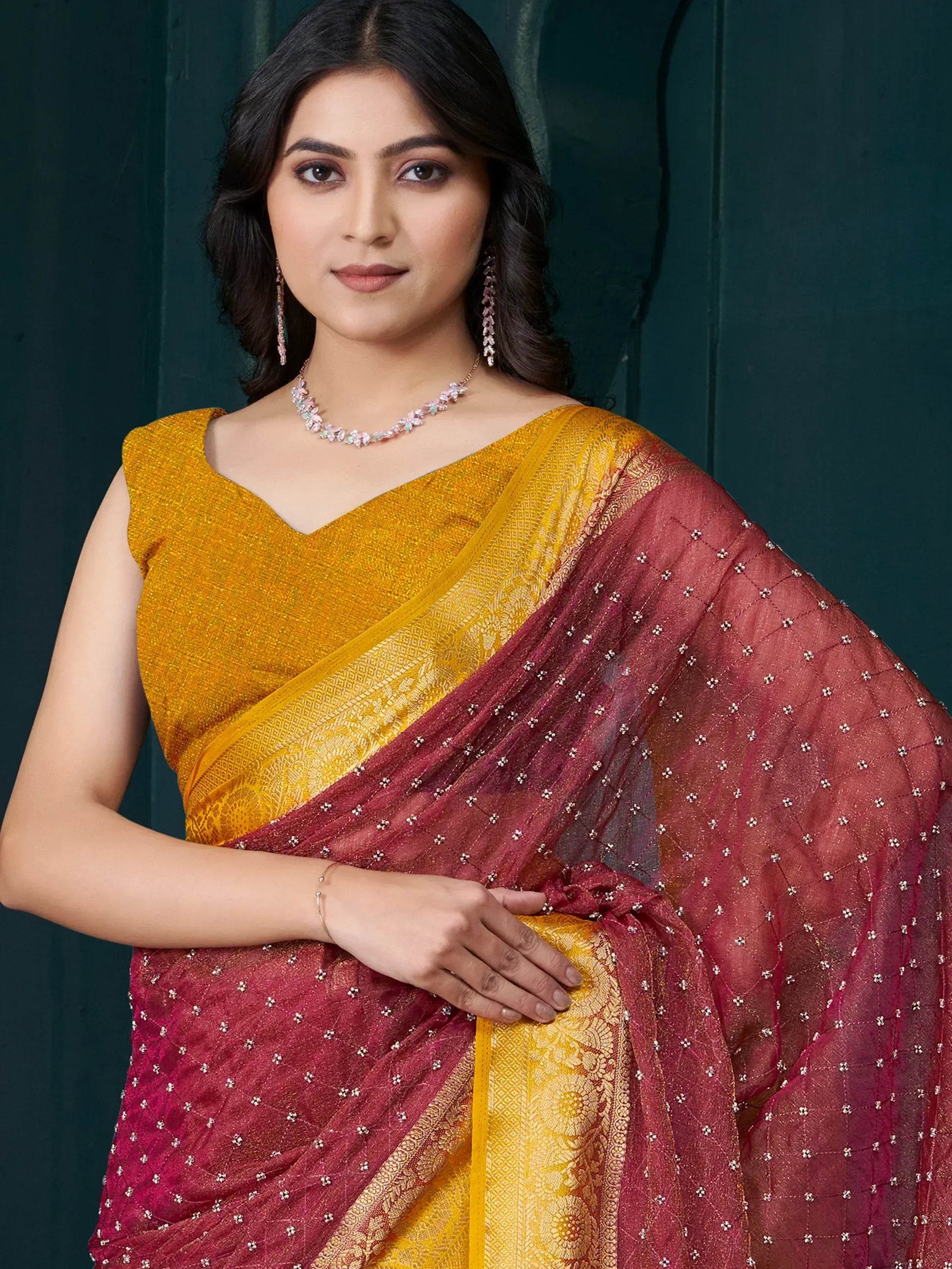 Elegant maroon and gold saree with intricate embroidery and designer blouse