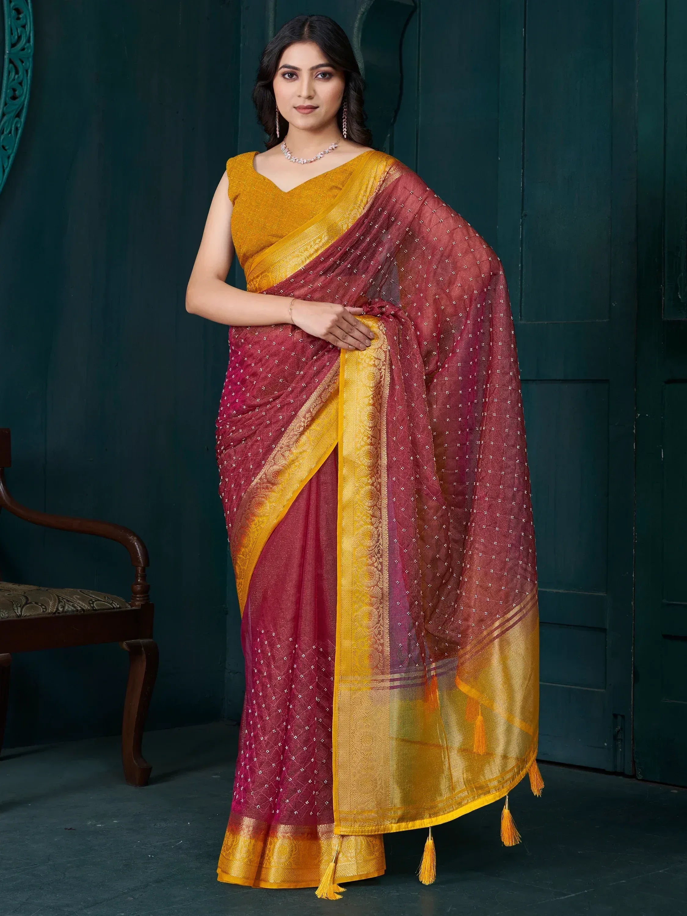 Elegant maroon and gold saree with intricate embroidery and tassels, perfect for Indian ethnic wear.